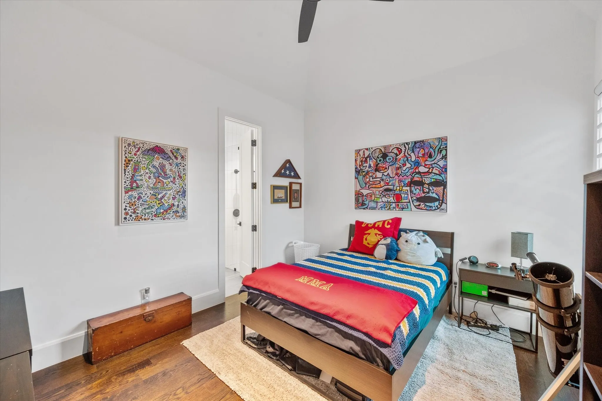 High ceilings and dark wood-finish flooring characterize this room, featuring a door with black hardware