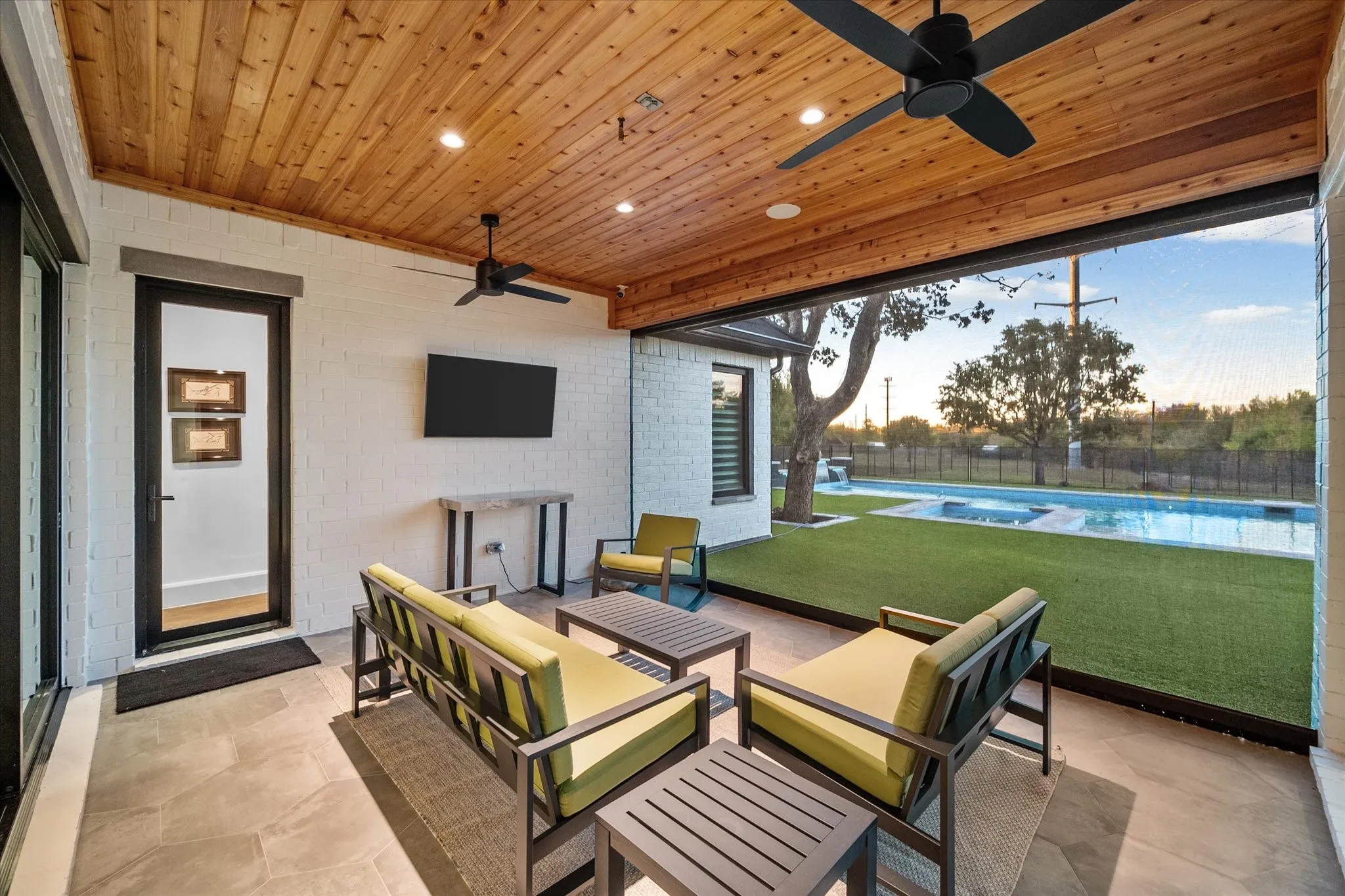 Covered outdoor living area featuring a tongue-and-groove wood ceiling, recessed lighting, and ceiling fans