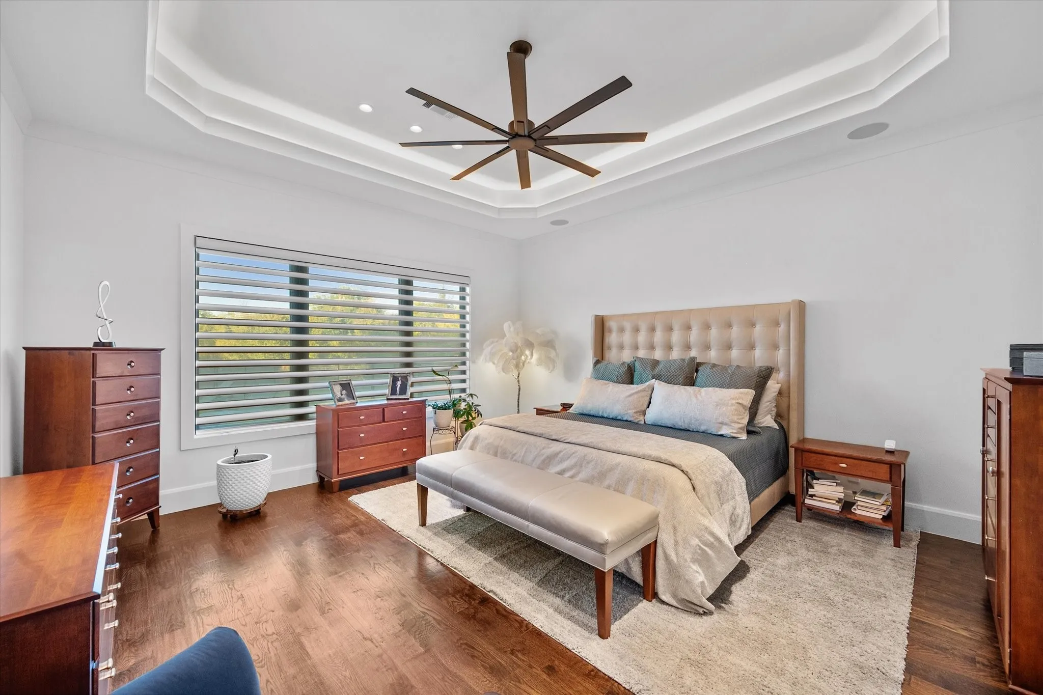 Spacious room featuring wood-finish flooring and a tray ceiling with integrated lighting