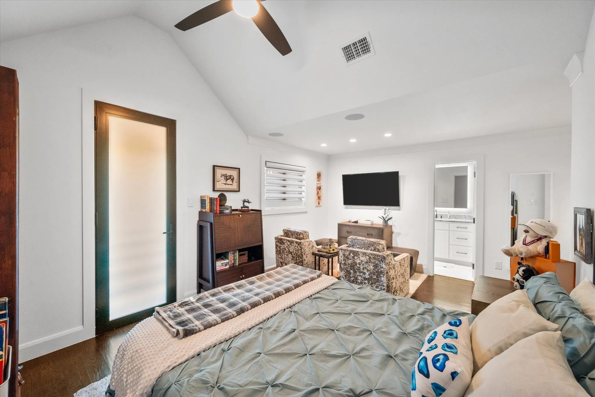 Vaulted ceiling bedroom featuring dark wood-finish flooring, a contemporary ceiling fan, recessed lighting, and a frosted glass door