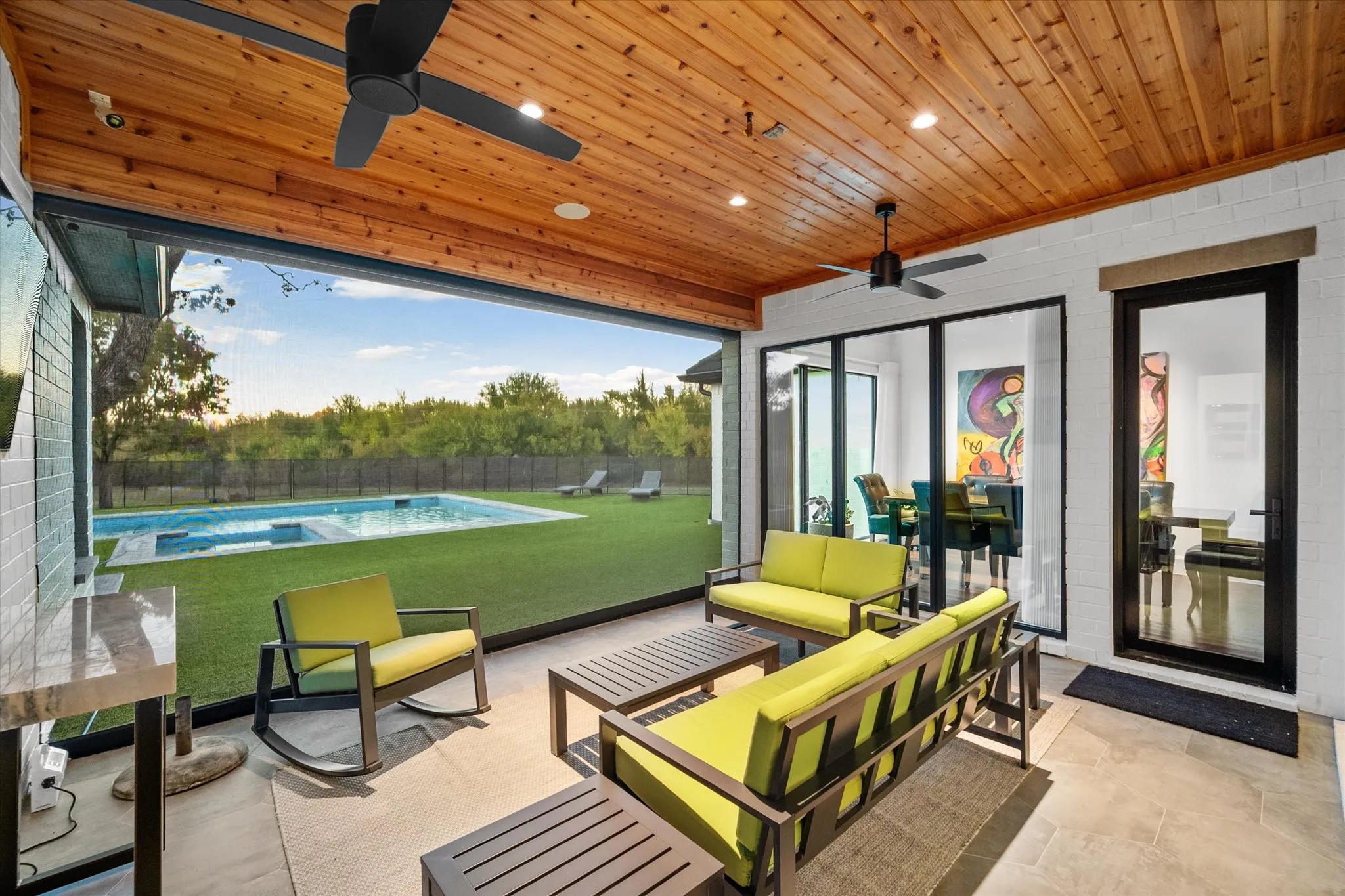 Expansive covered patio featuring a wood-finish ceiling, recessed lighting, and dual ceiling fans