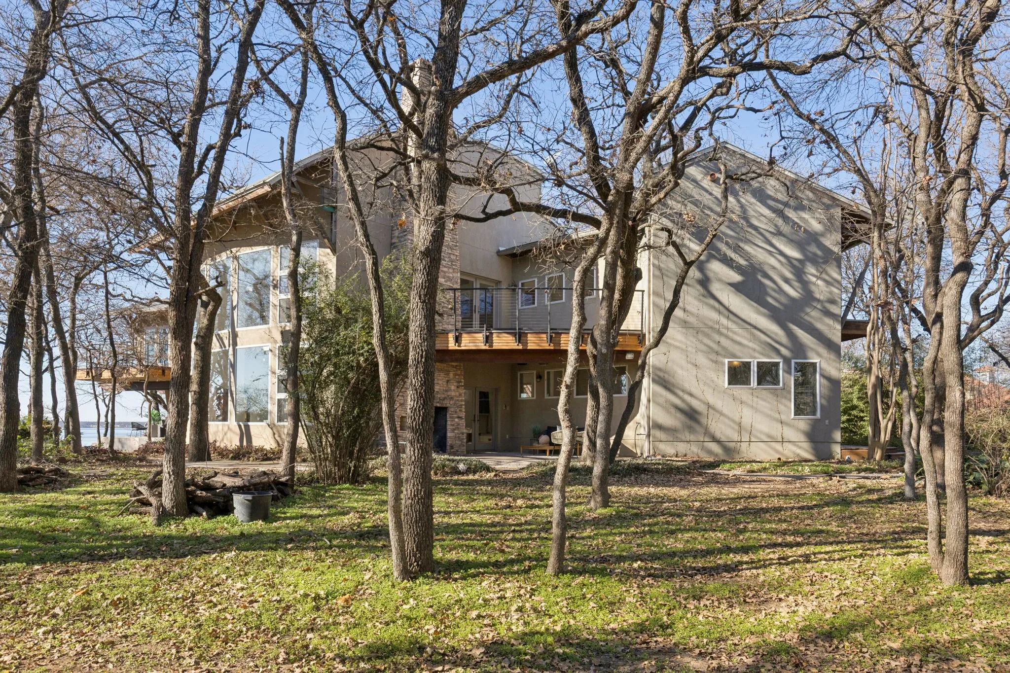 Side view of property featuring a patio area, a yard, and a balcony