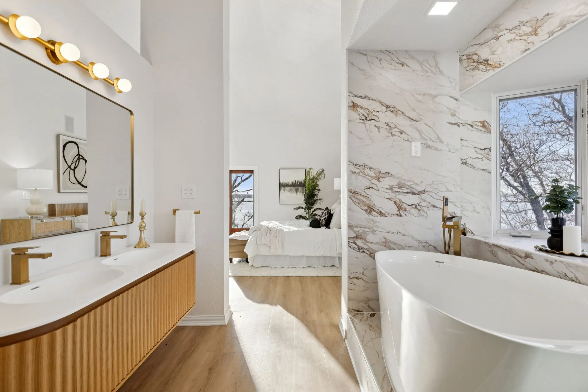 Full bathroom featuring ensuite bathroom, a freestanding tub, double vanity, and plenty of natural light