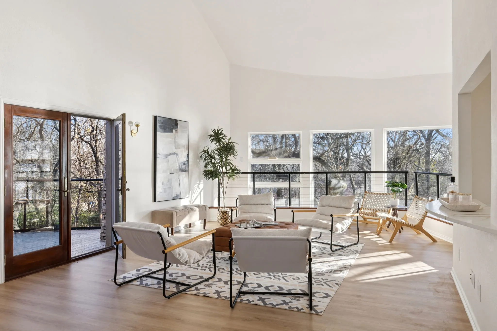 Living room with high vaulted ceiling, plenty of natural light, and light wood-type flooring