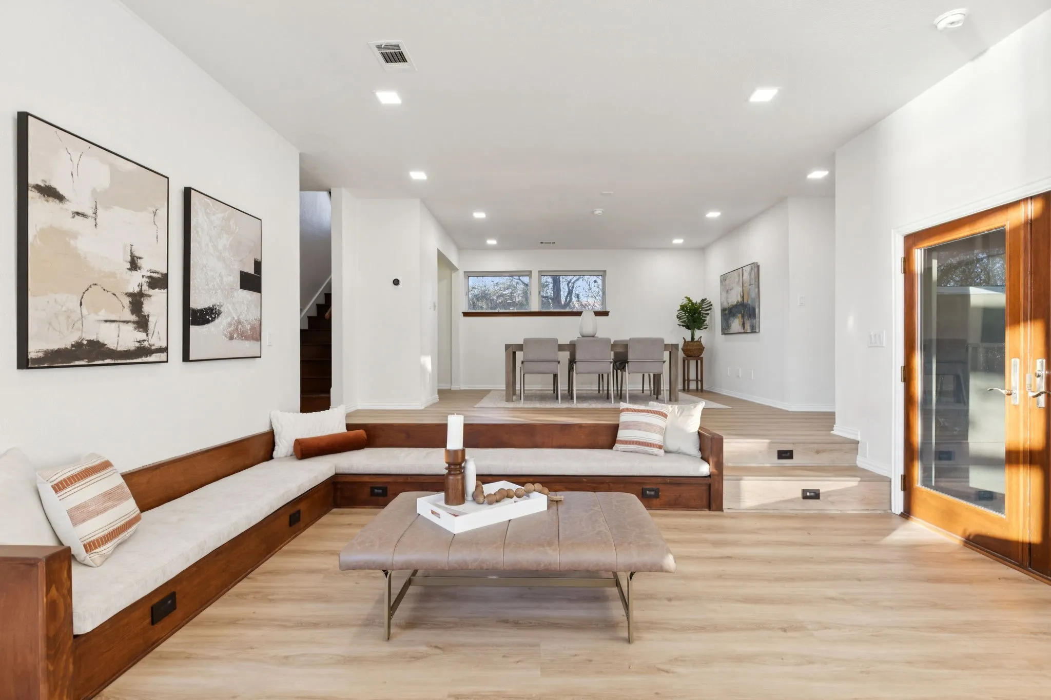 Sunken living room with light wood-style flooring, recessed lighting, and stairs