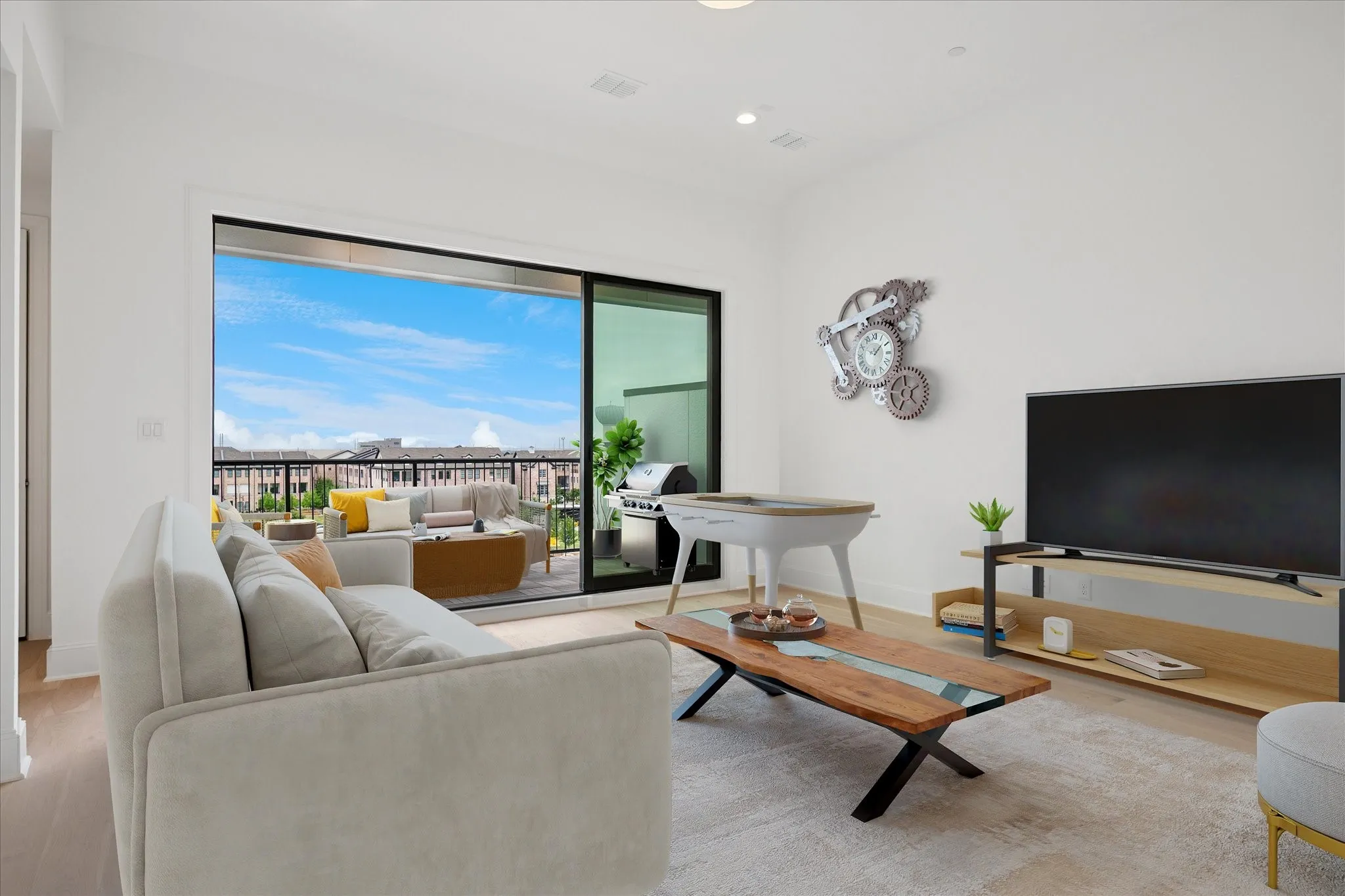 Bright living area featuring wood-finish flooring, white walls, and recessed lighting
