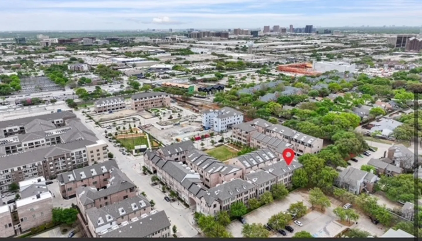 Aerial perspective showcasing a residential community with multi-story townhomes and mature trees