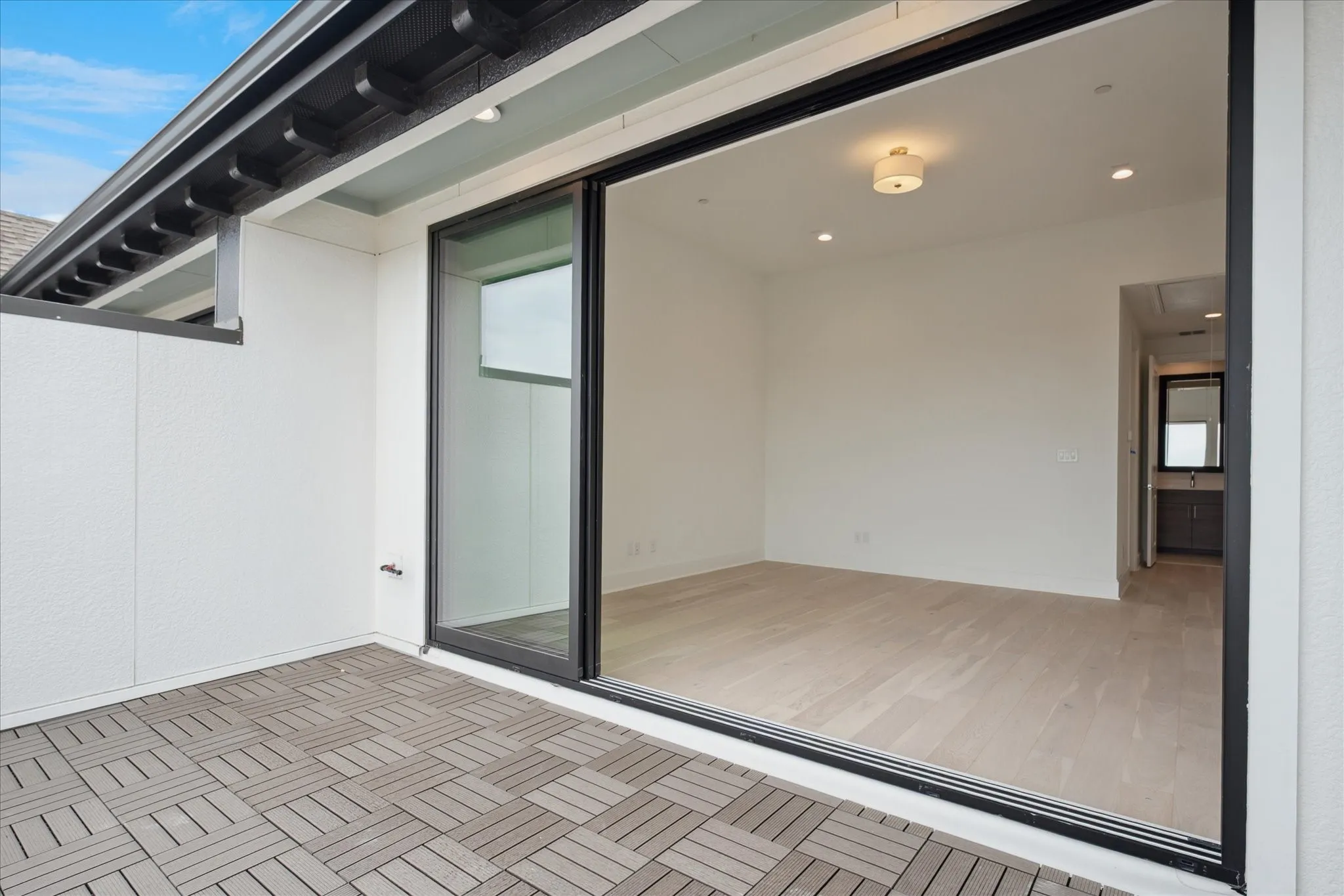 Outdoor patio featuring geometric tile flooring and a black sliding glass door