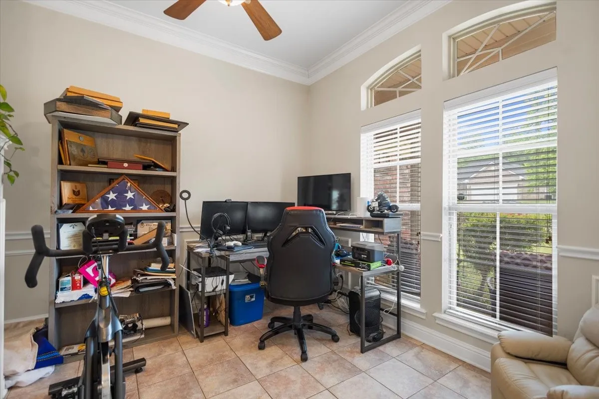 Versatile room featuring tile flooring, crown molding, and a ceiling fan