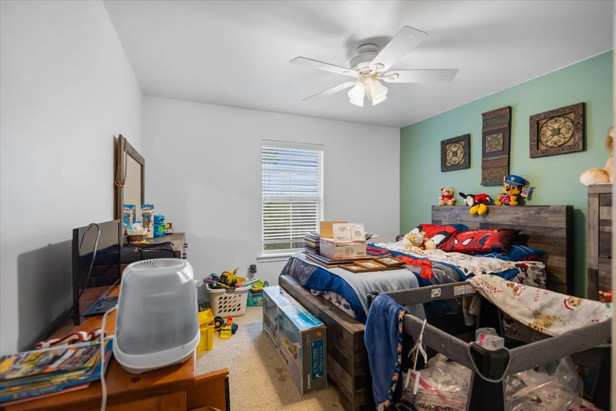 Room featuring a window with blinds, a ceiling fan, and two-tone wall paint