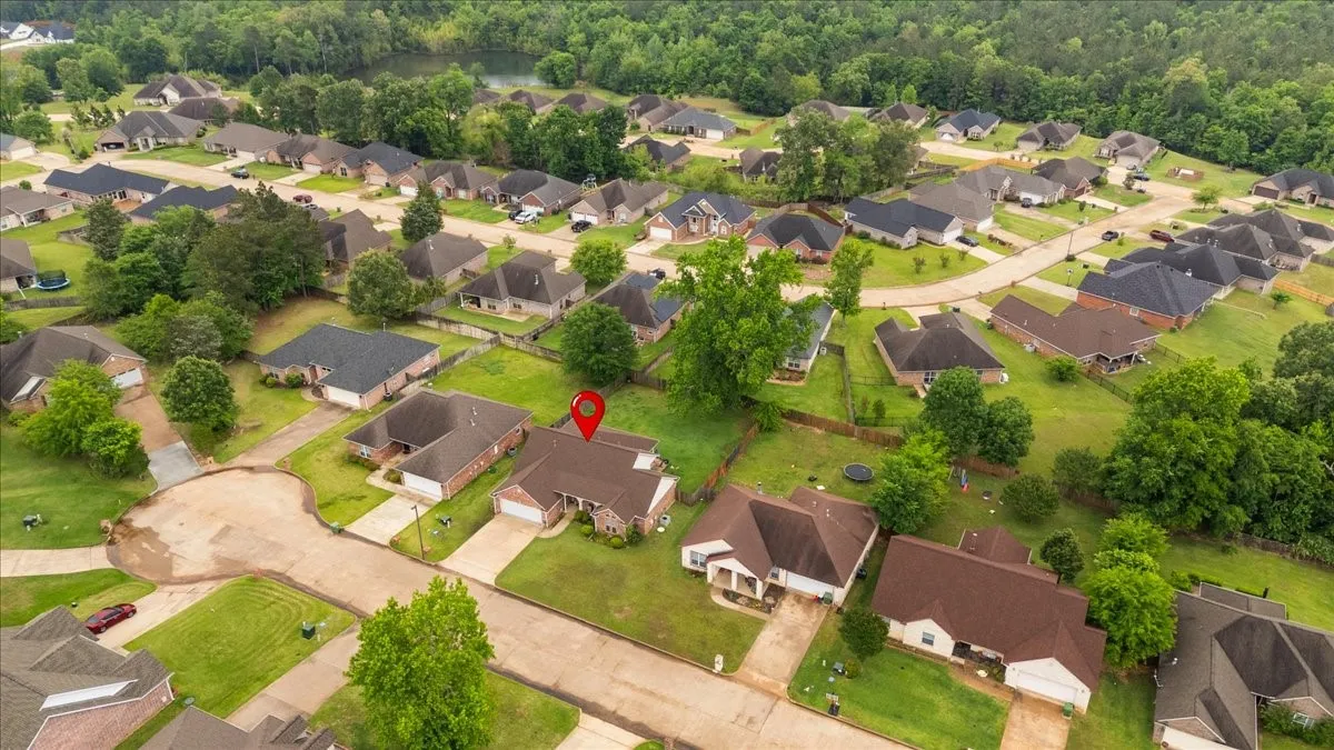 Residential neighborhood featuring single-story homes with attached garages, paved driveways, and manicured lawns