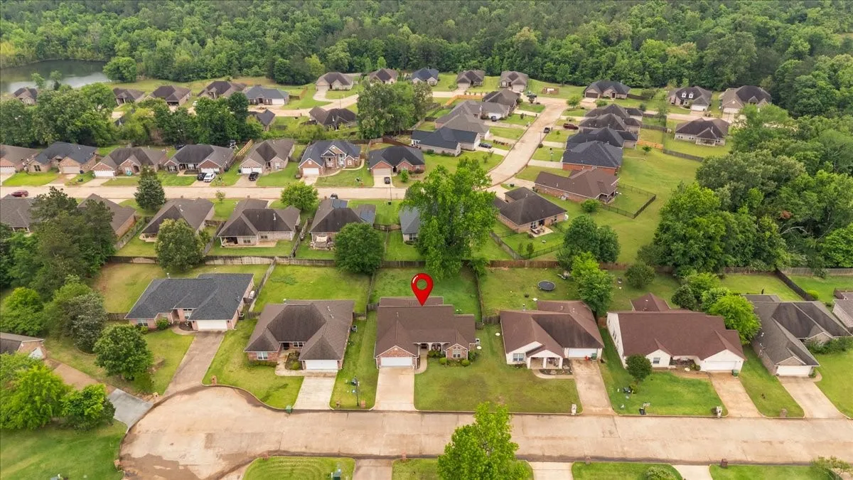 Aerial perspective of a residential neighborhood featuring homes with dark shingle roofs and manicured lawns