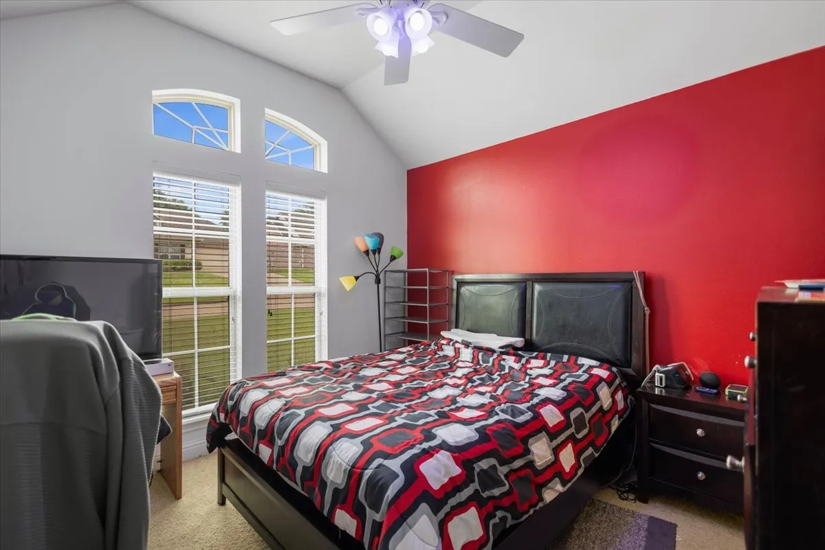 Vaulted ceiling bedroom with a prominent red accent wall