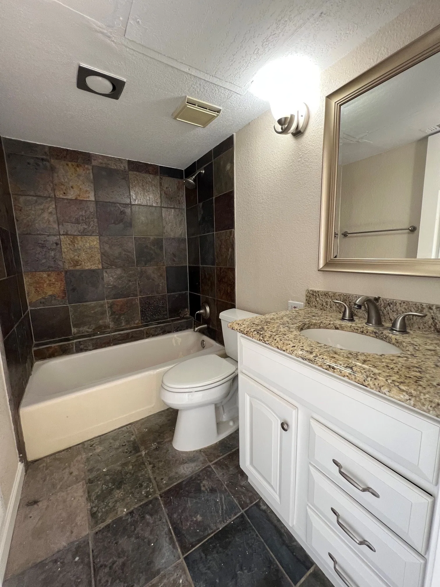 White vanity with granite countertop, undermount sink, and brushed nickel hardware
