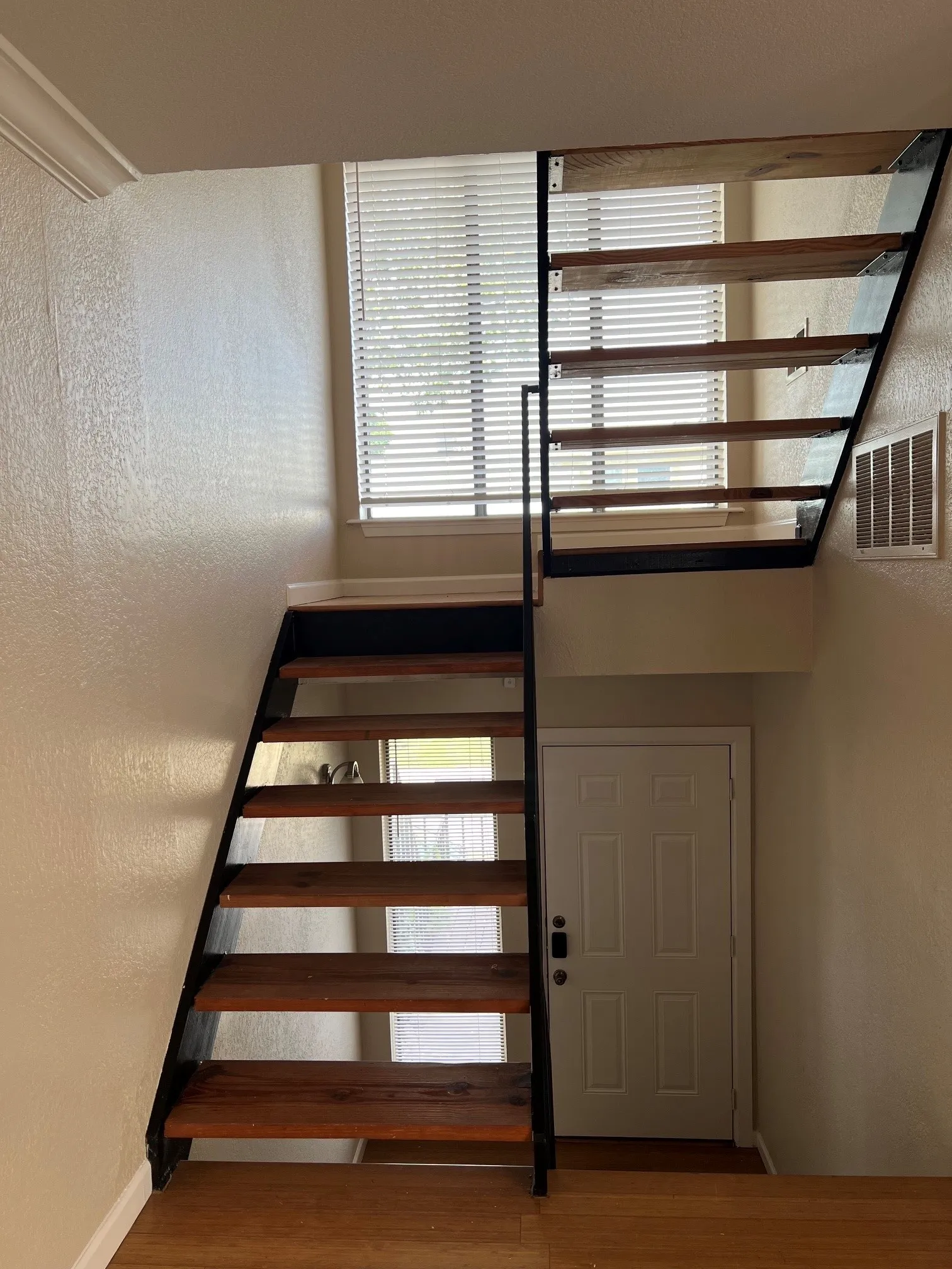Open-tread staircase with wood finish to living areas.