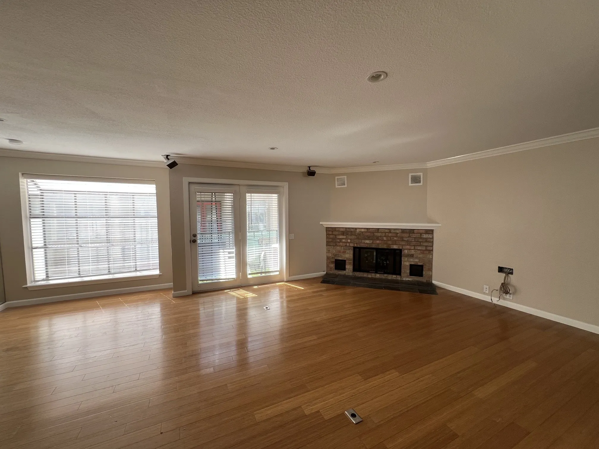 Hardwood flooring, brick fireplace with mantel, double-paned windows, double-paned French doors, and crown molding