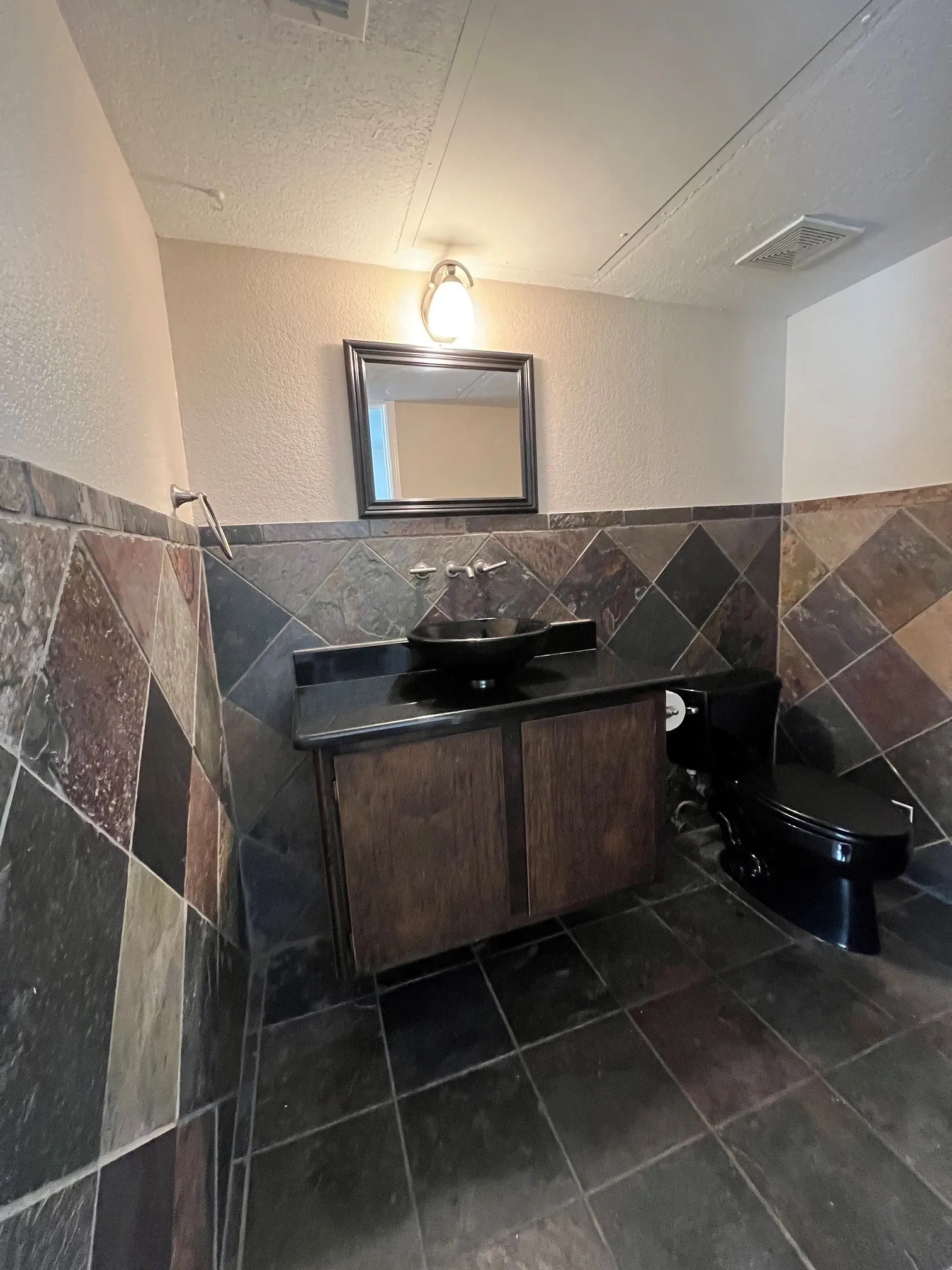Gorgeous guest bathroom with real stone-clad walls and flooring