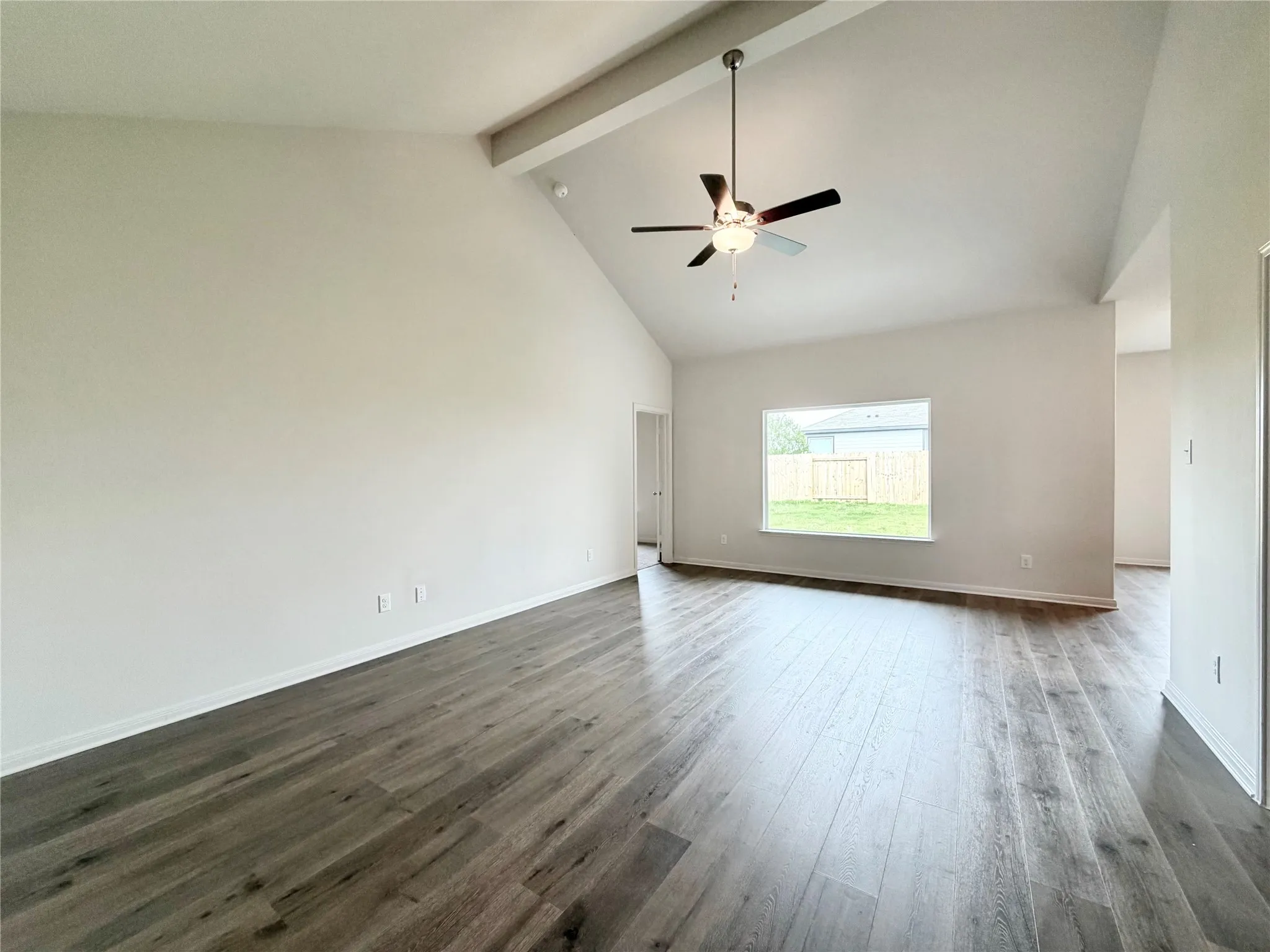 High ceilings and fan with large window for a back yard view