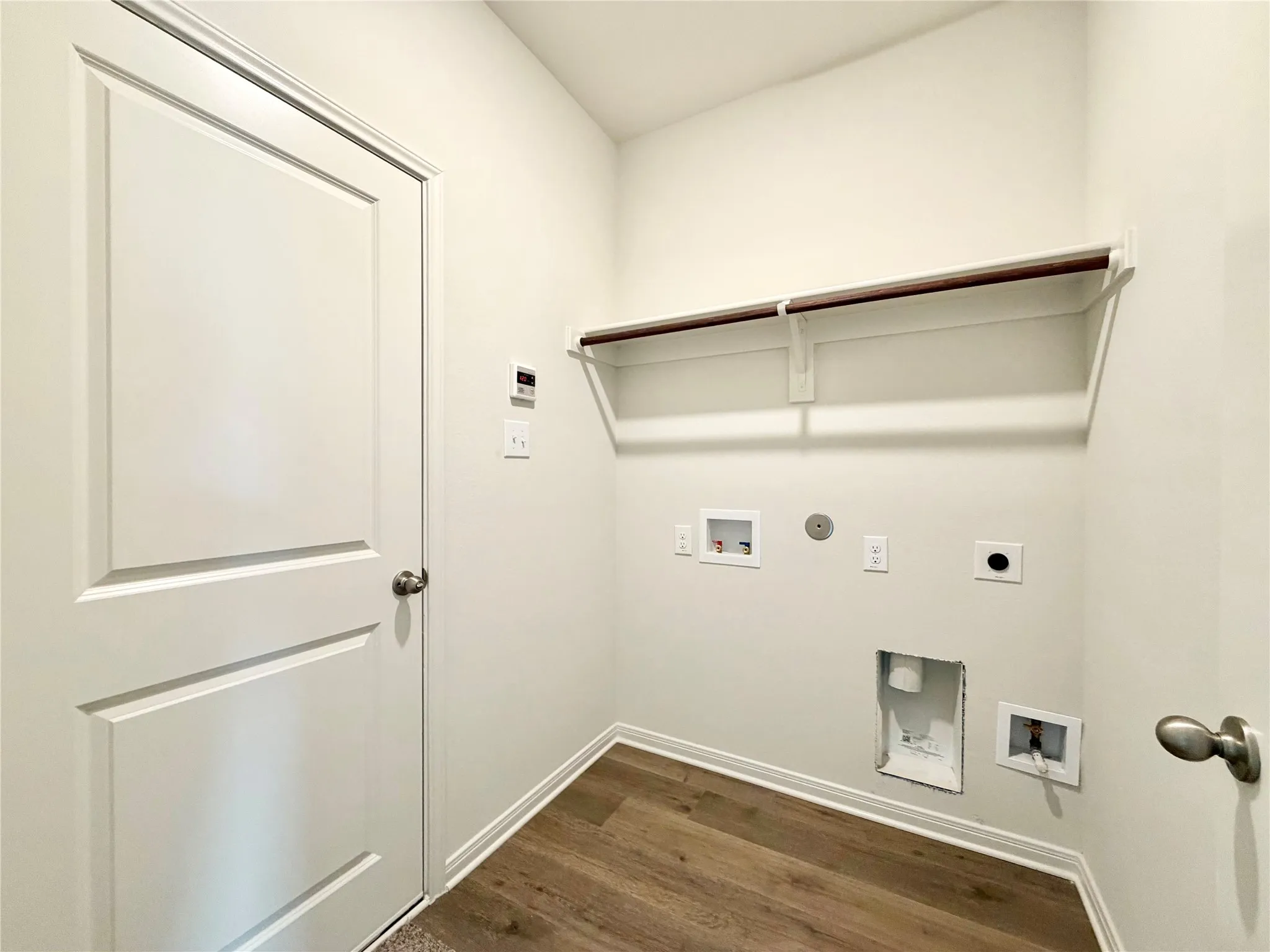 Laundry room off the entry hallway connecting to the garage