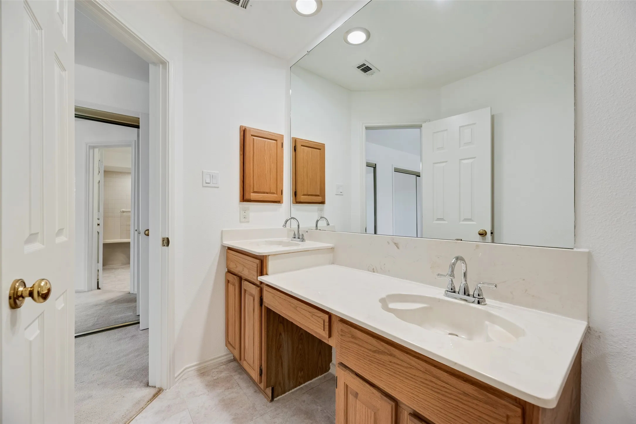 Double vanity with integrated sinks and a large wall-mounted mirror