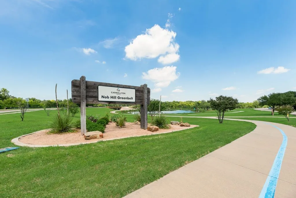 Nob Hill Greenbelt entrance featuring a wooden sign with landscaping
