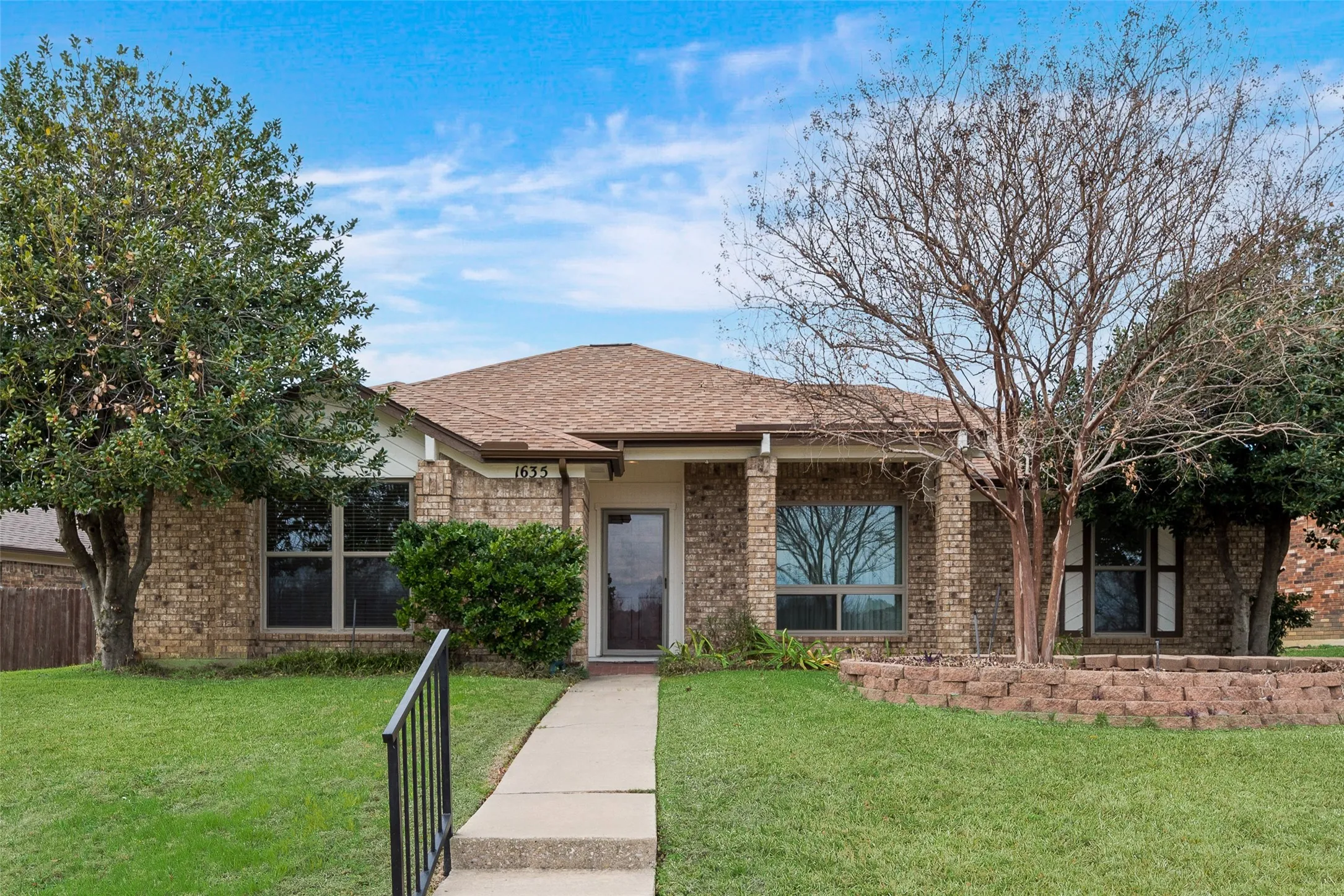 Brick exterior featuring a gabled roof and covered entry