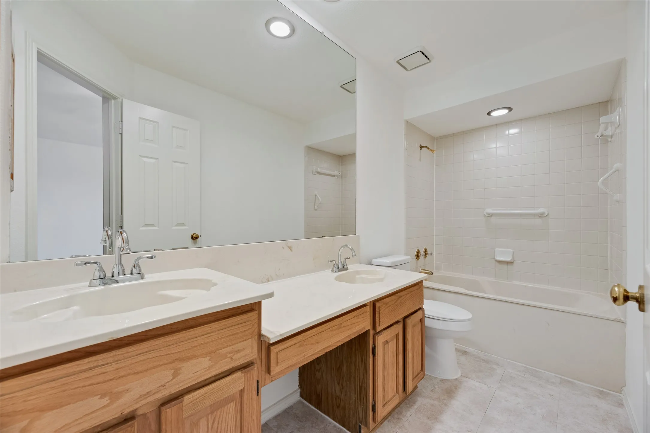 Bathroom with a double vanity featuring wood cabinetry and white countertops