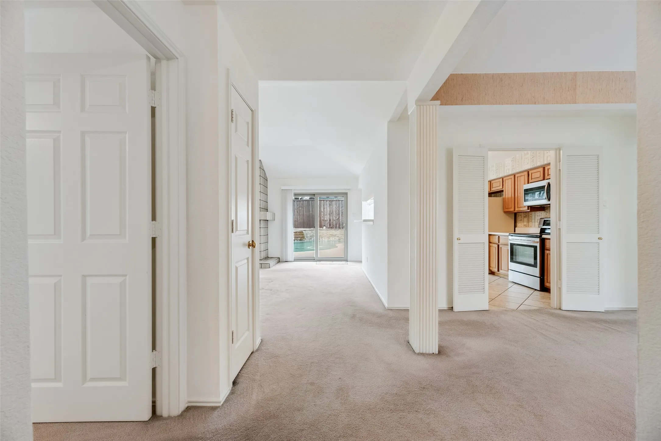 Carpeted living space with white interior doors and white wall finishes