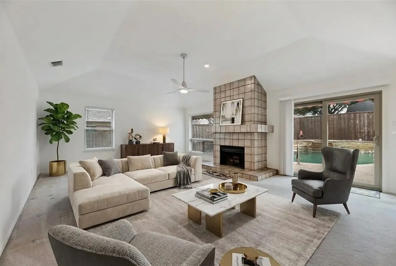 Vaulted ceiling living room featuring a tiled fireplace, ceiling fan, and sliding glass door access to the backyard with a pool