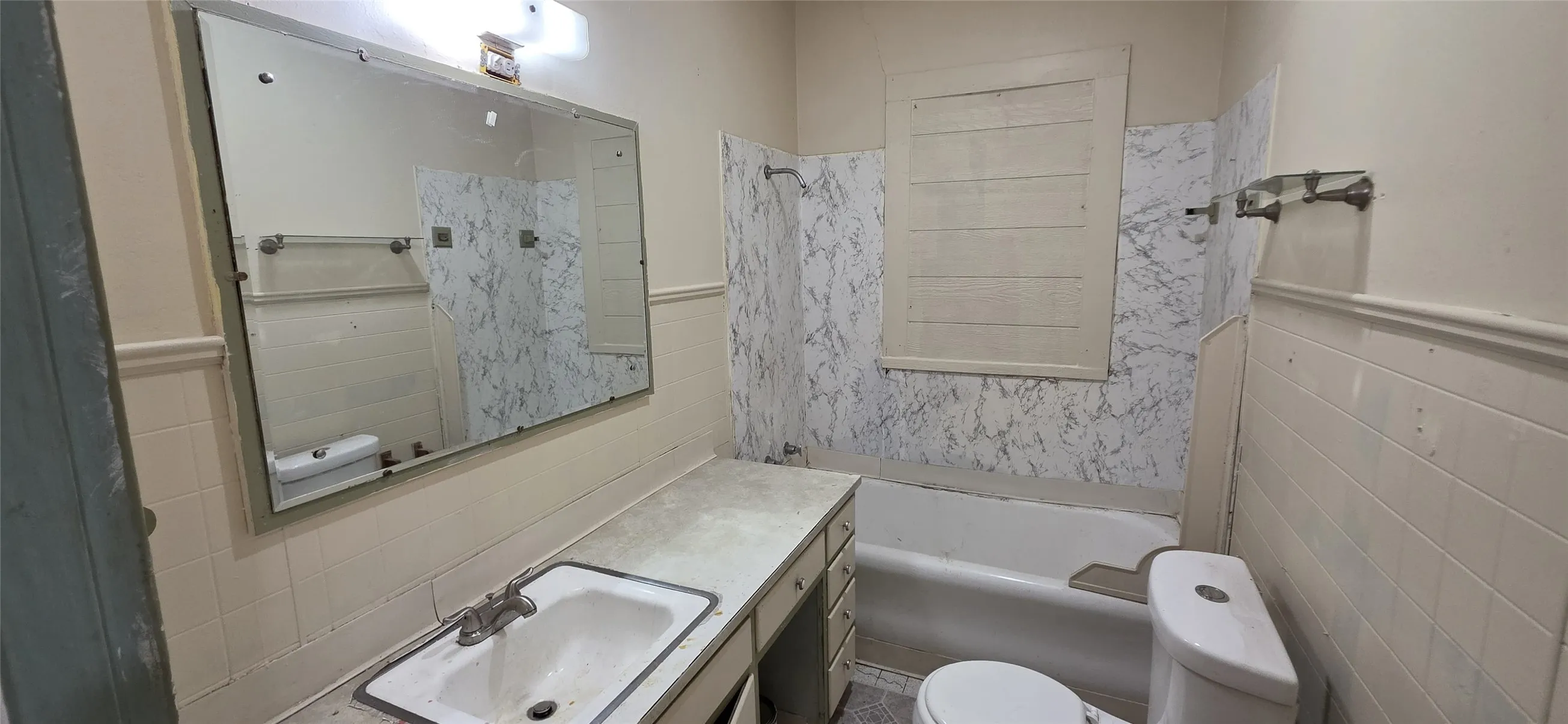 Bathroom featuring a built-in vanity with integrated sink, wall-mounted mirror, and a full-size bathtub
