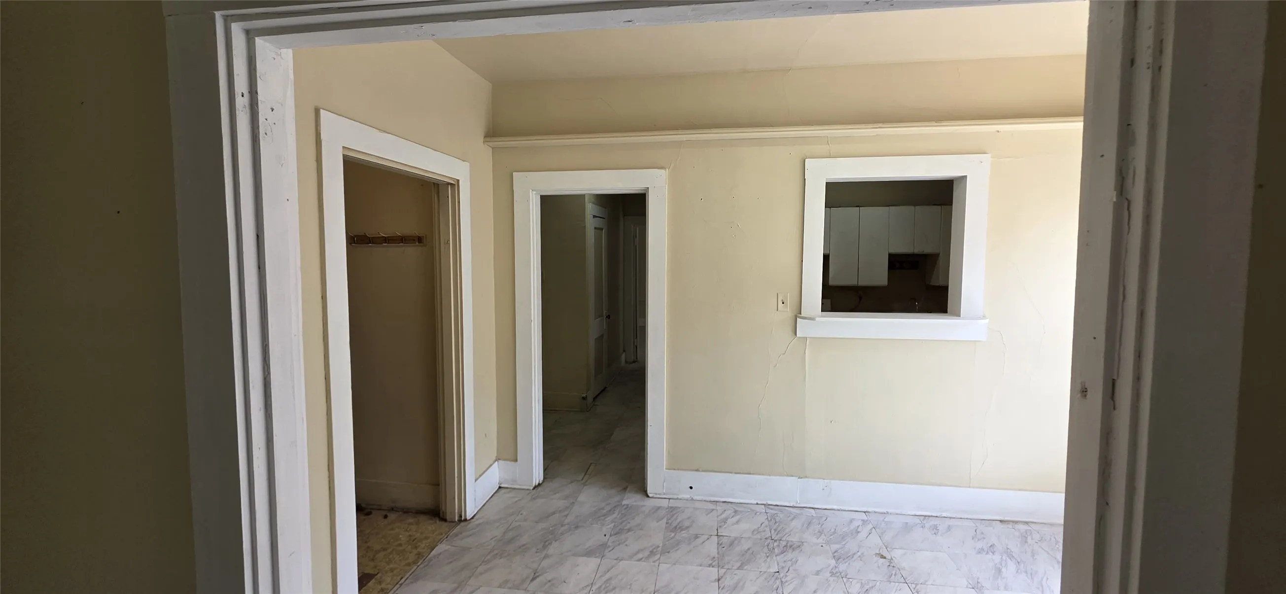 Room featuring light-toned walls, white trim, and patterned flooring