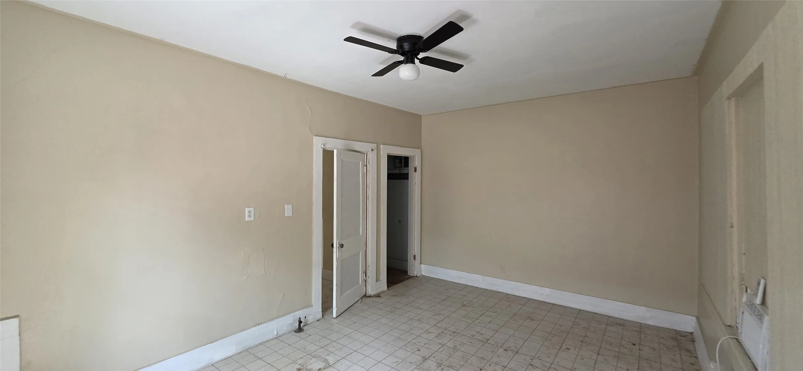Room featuring neutral-toned walls, white trim, and a black ceiling fan with an integrated light fixture