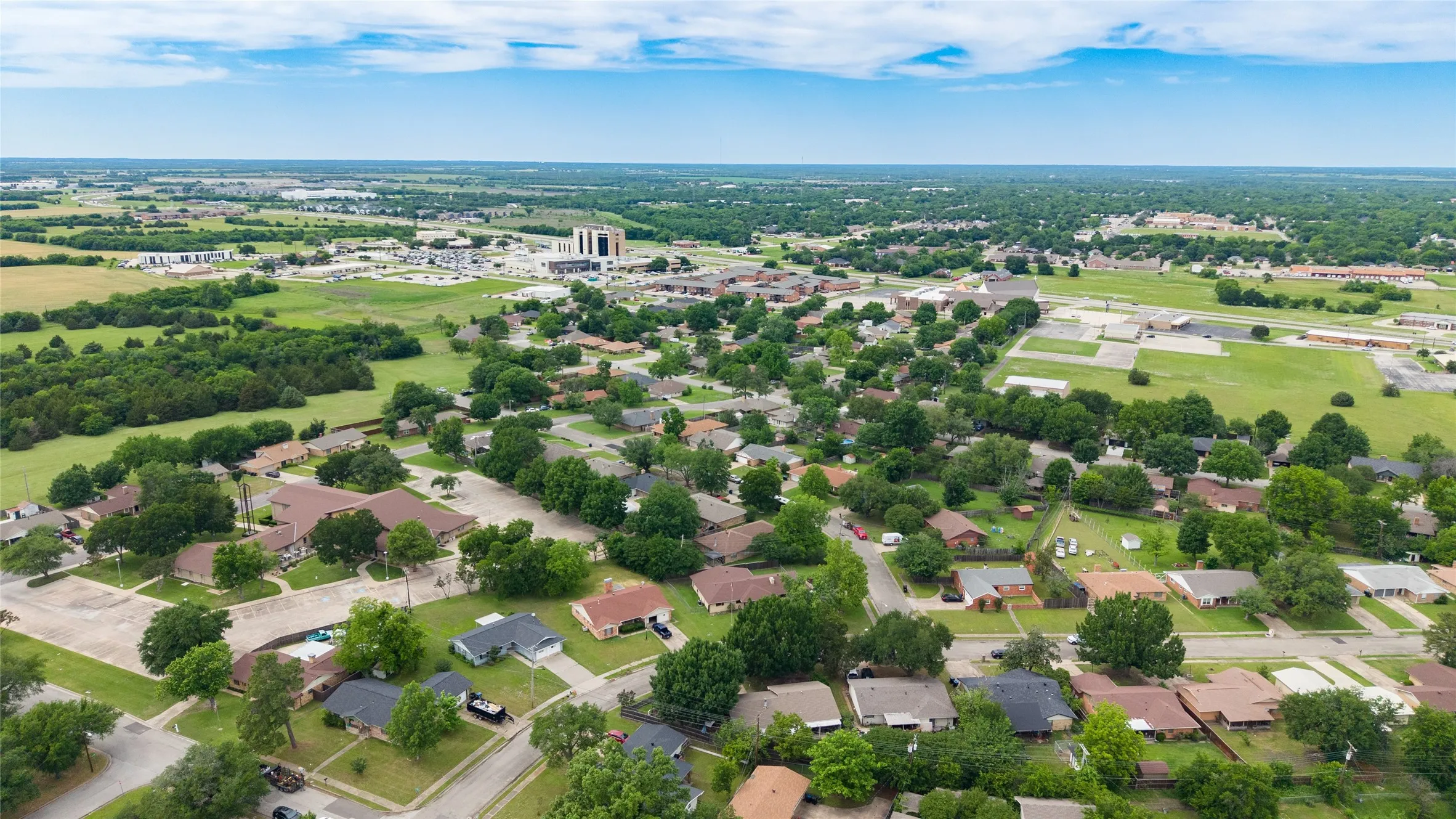 Aerial perspective showcasing a residential neighborhood with surrounding green spaces