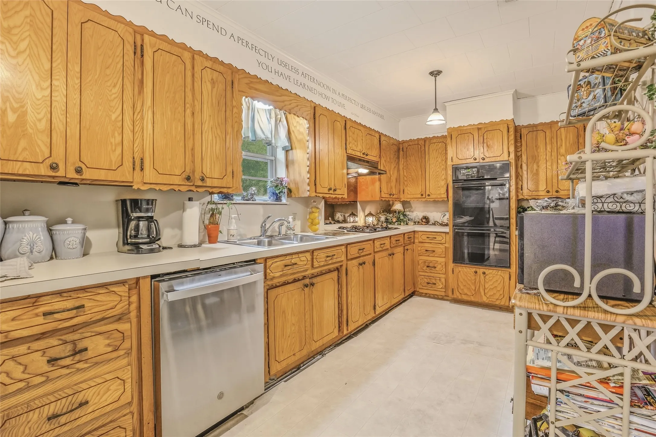 Kitchen featuring wood cabinetry, white countertops, a stainless steel dishwasher, and a built-in double oven