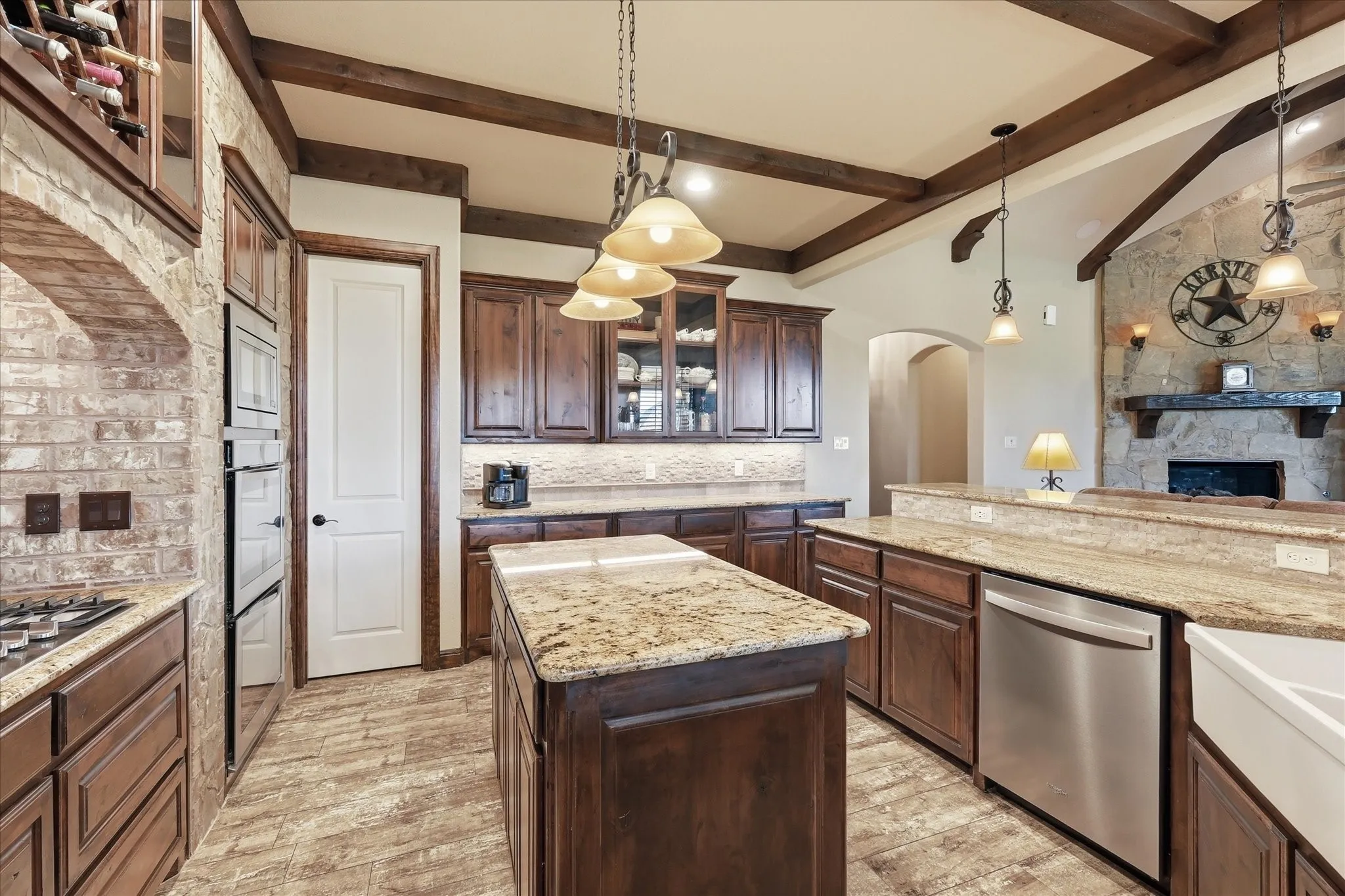 Kitchen featuring wood-finish flooring, dark wood cabinetry, and granite countertops