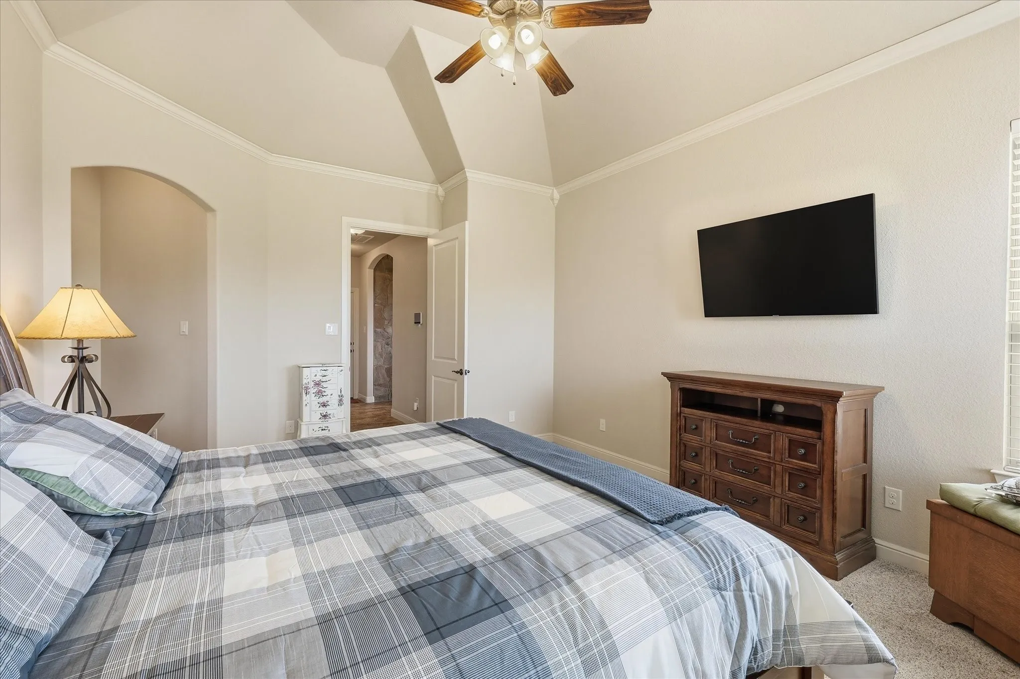 Vaulted ceiling with crown molding and ceiling fan