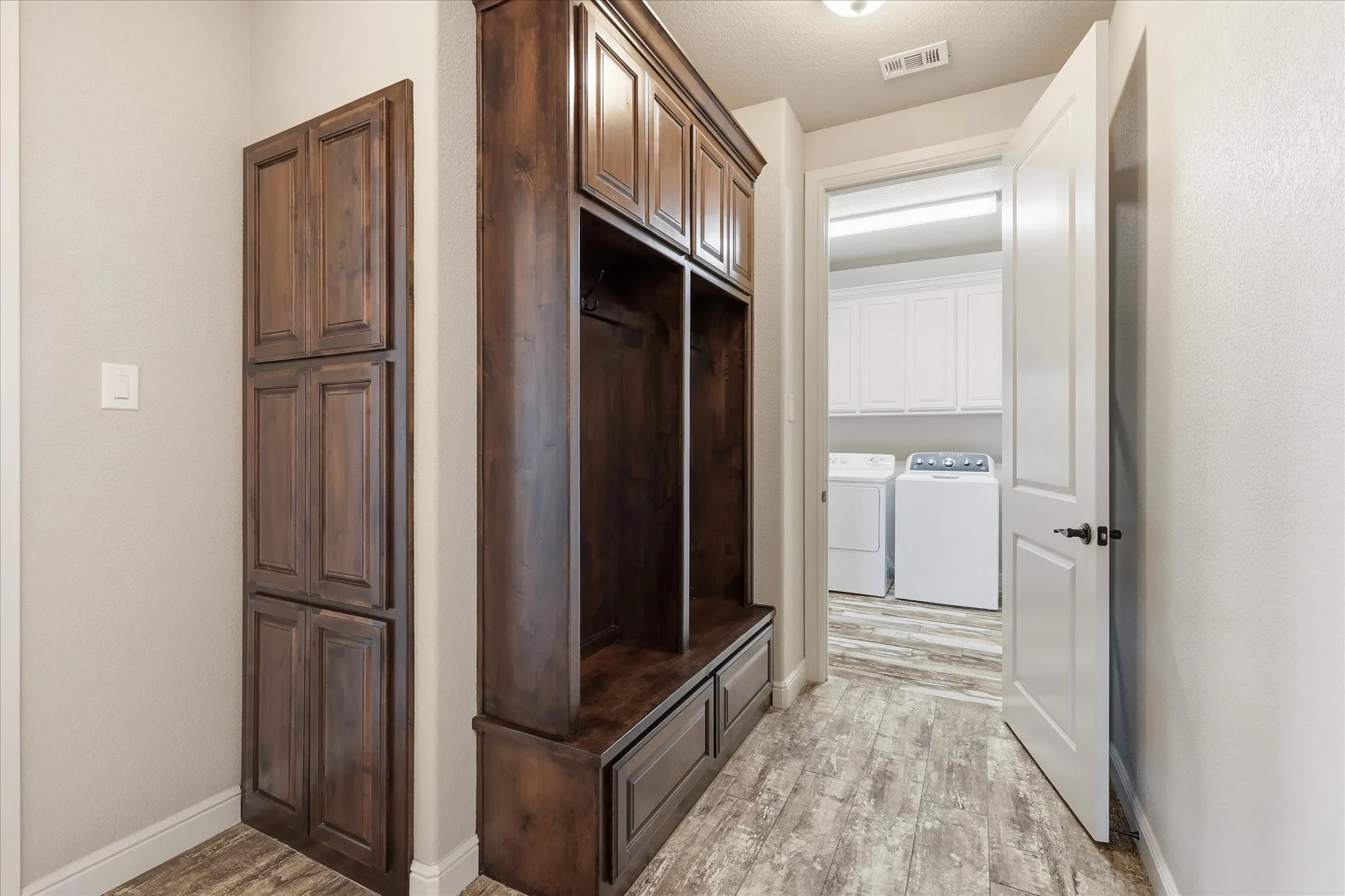 Built-in wood-finish cabinetry and bench with storage drawers