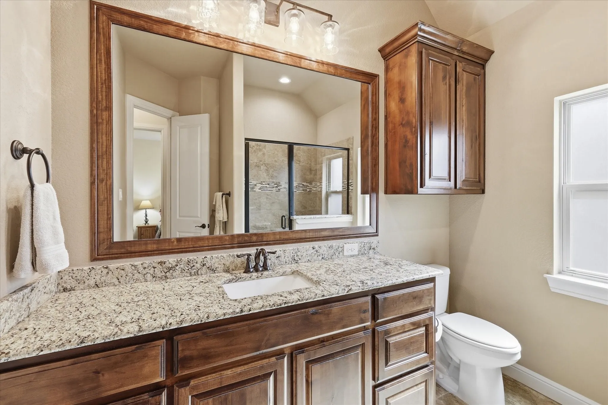 Bathroom vanity featuring a light-toned countertop, a rectangular undermount sink, and dark wood-finish cabinetry