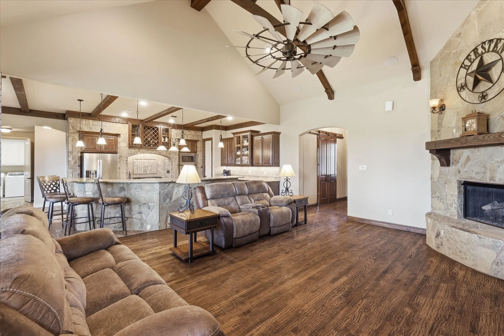 Vaulted ceiling with exposed wood beams and a unique ceiling fan