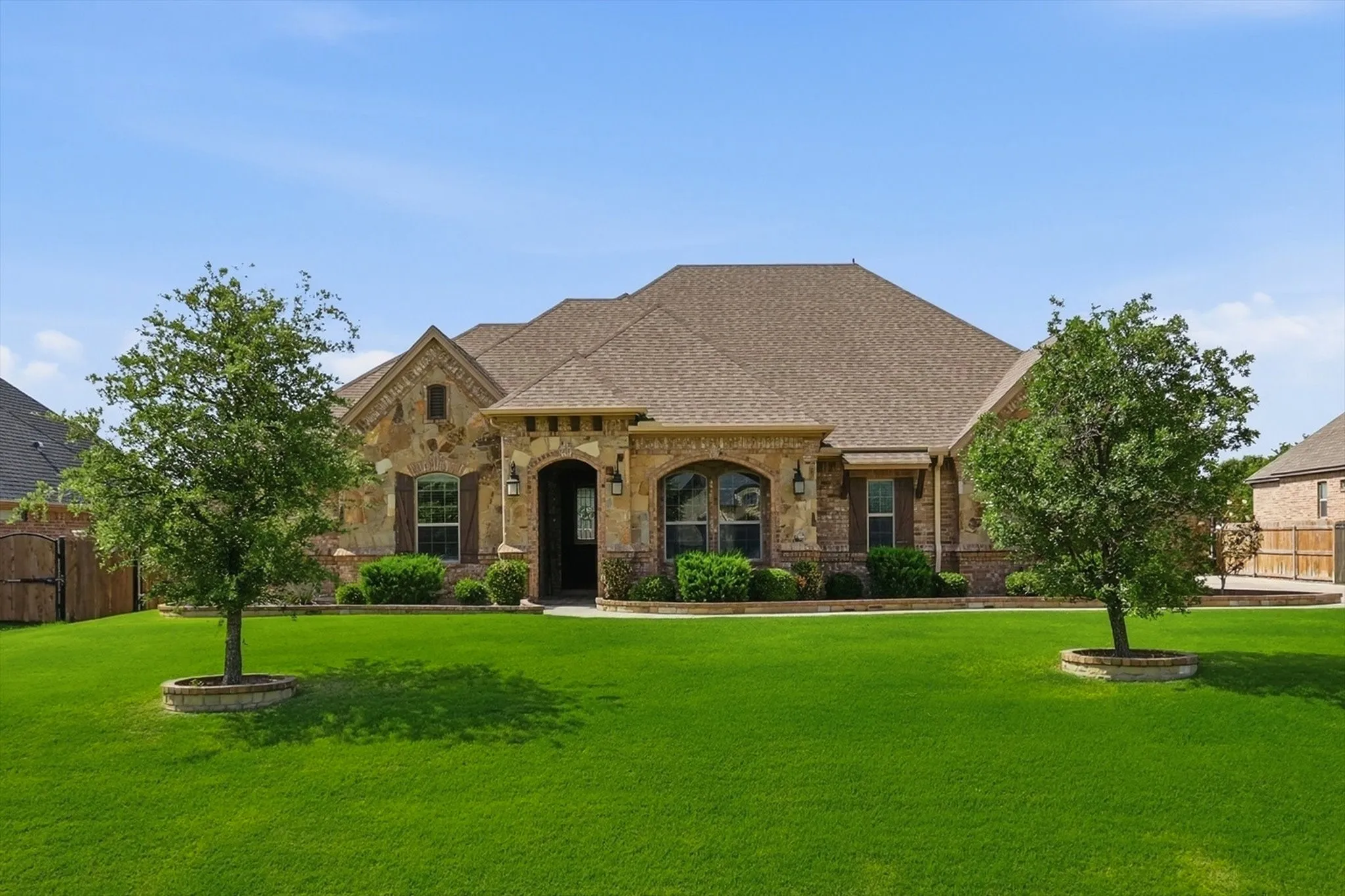 Stone and brick facade with an arched entry and decorative shutters