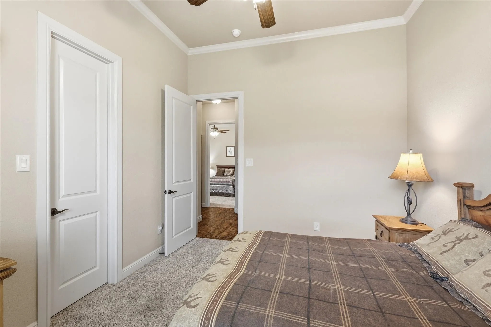 Bedroom featuring soft neutral wall tones, crown molding, and plush carpeting