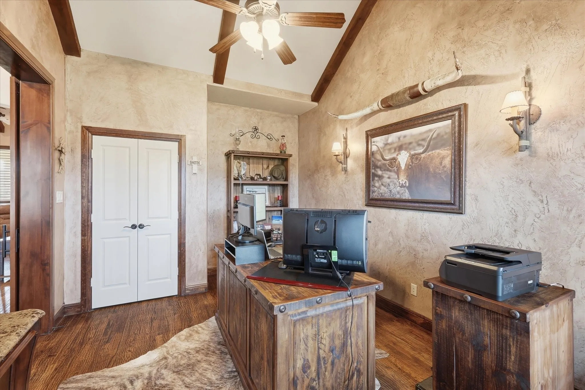 Room featuring vaulted ceilings with exposed wood beams, textured wall finishes, and wood-finish flooring