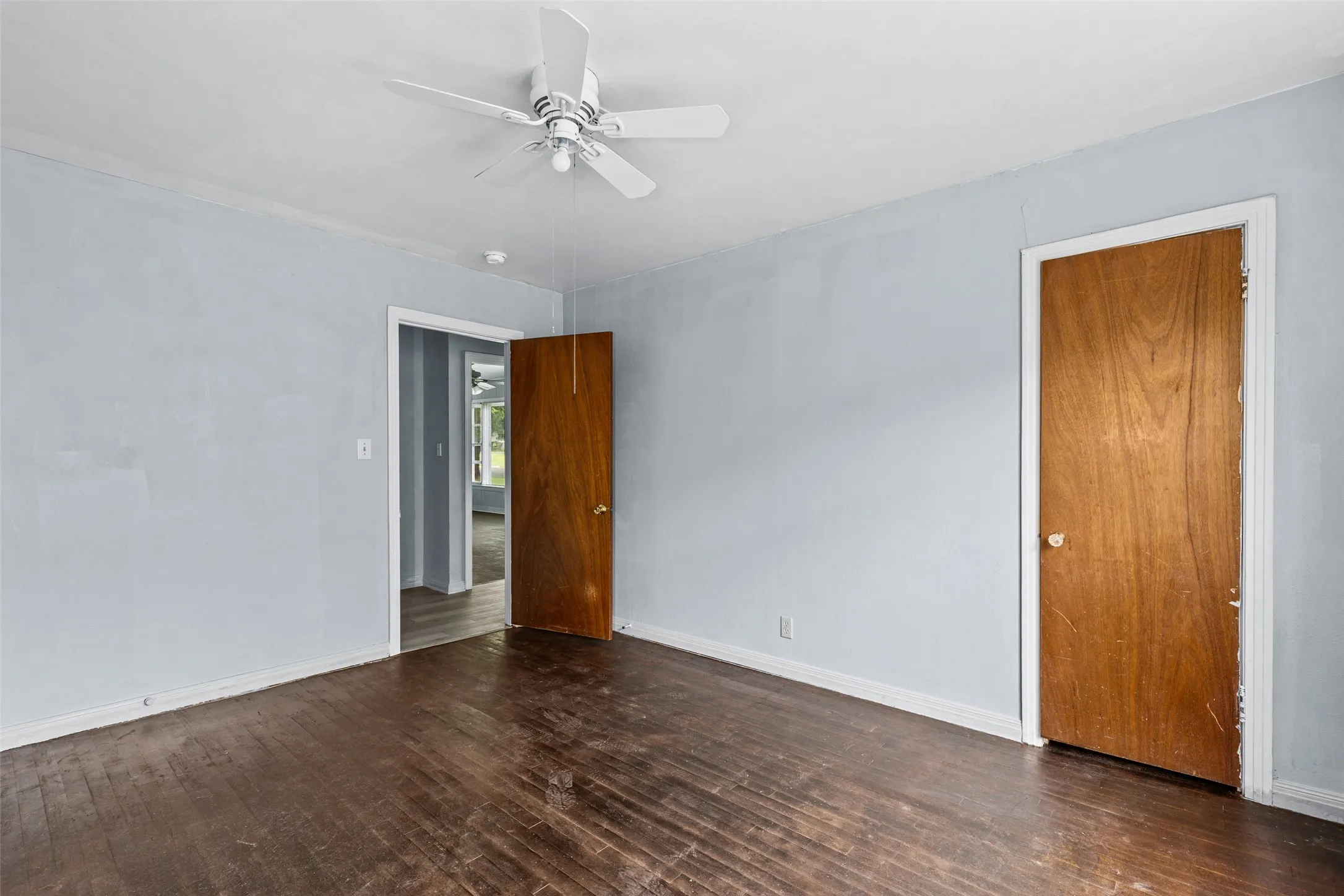 Light blue painted walls with white trim and a white ceiling fan