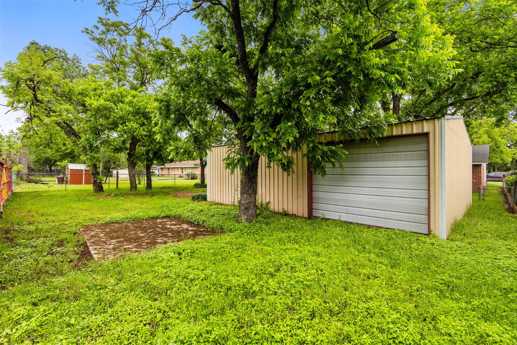 Detached garage featuring a metal roll-up door and corrugated siding