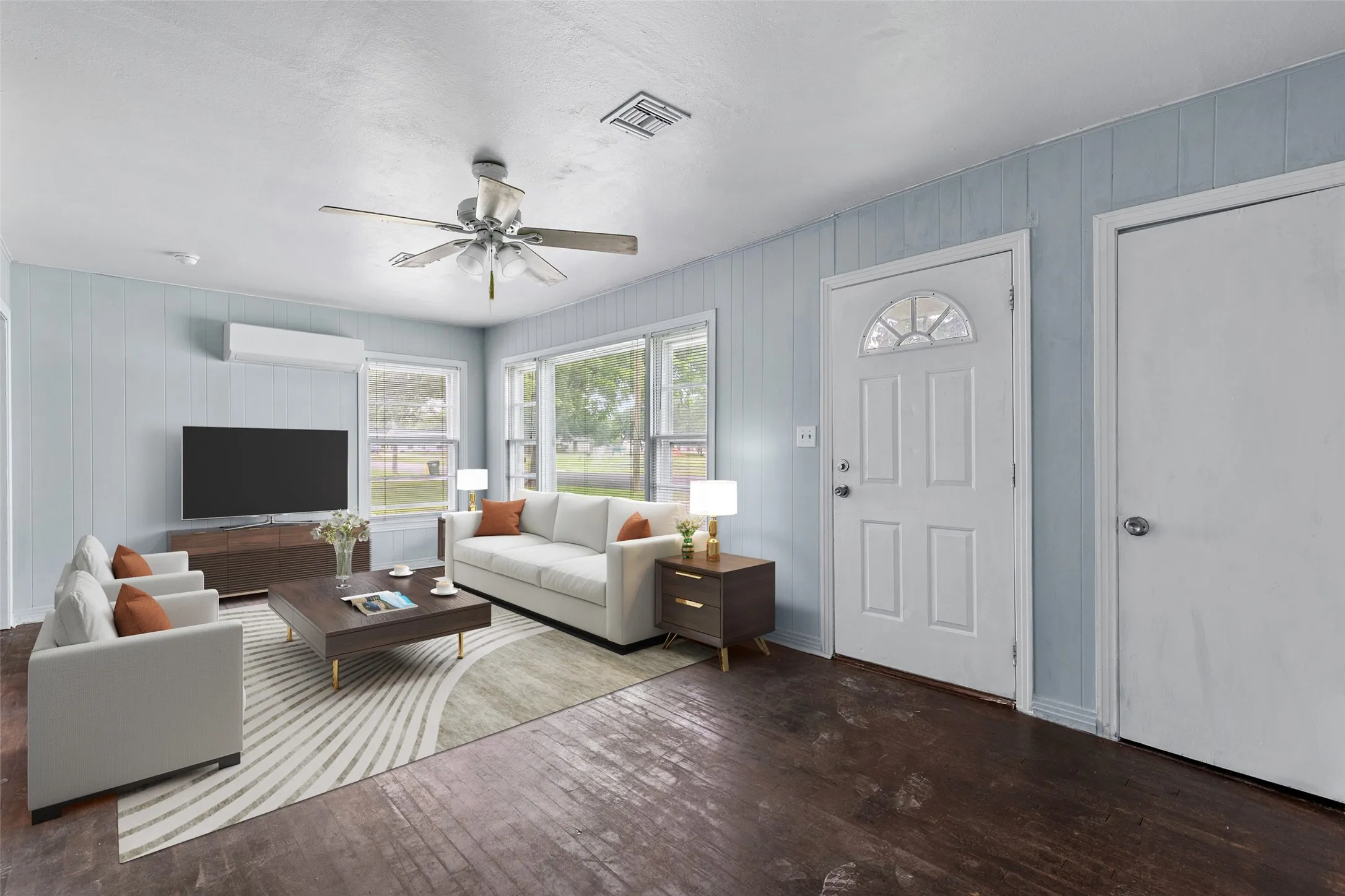 Virtual staging - Bright living area featuring wood-finish flooring, light blue paneled walls, and multiple windows