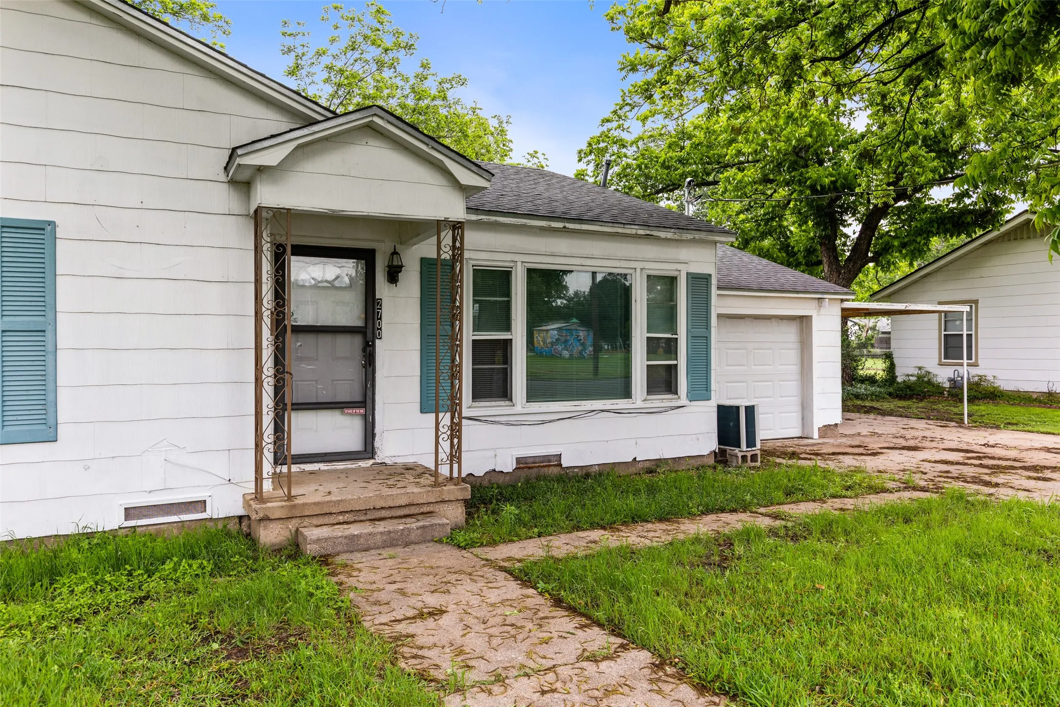 White siding exterior with blue louvered shutters and an attached garage