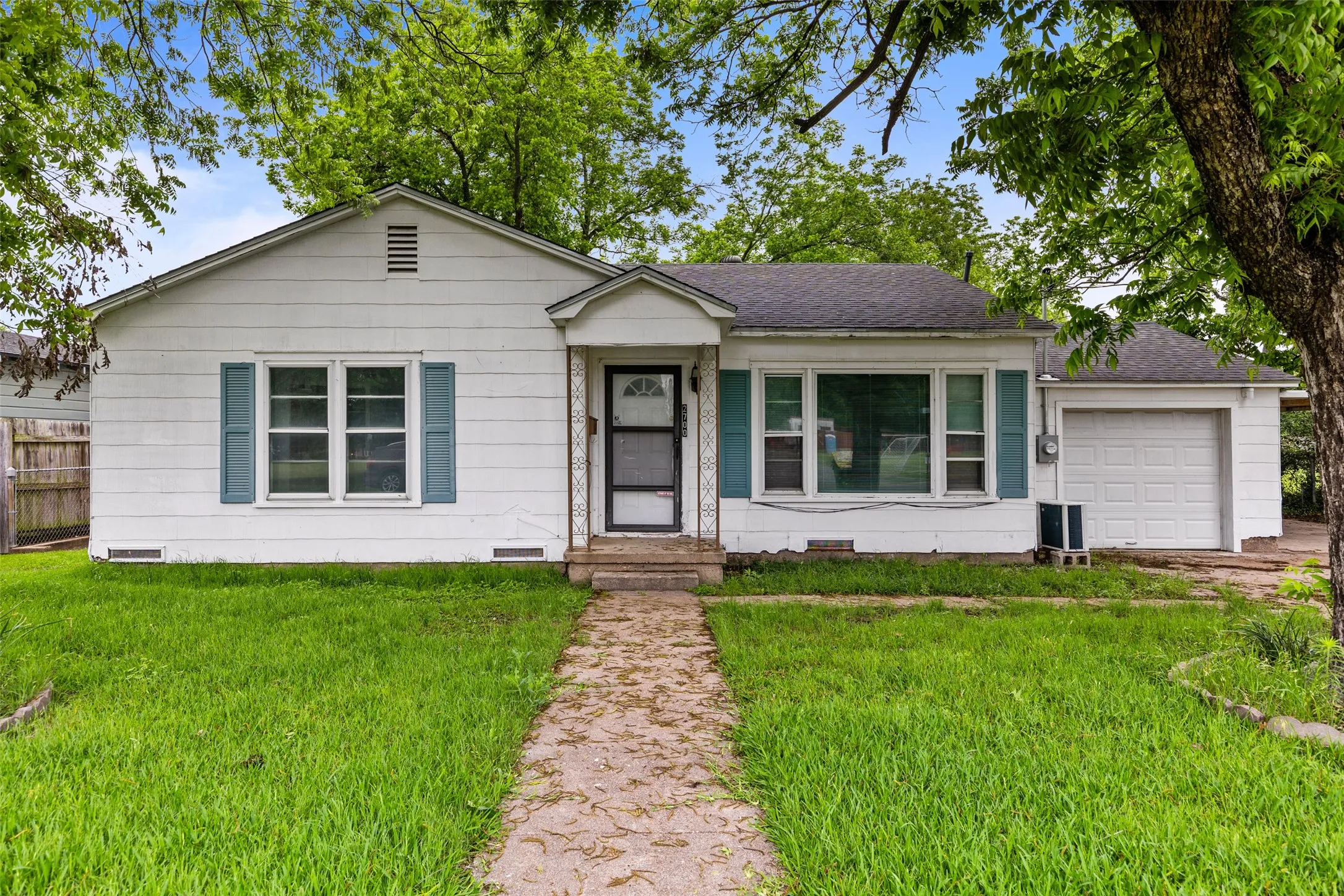 White siding home with a front porch, a single-car garage, and a concrete walkway