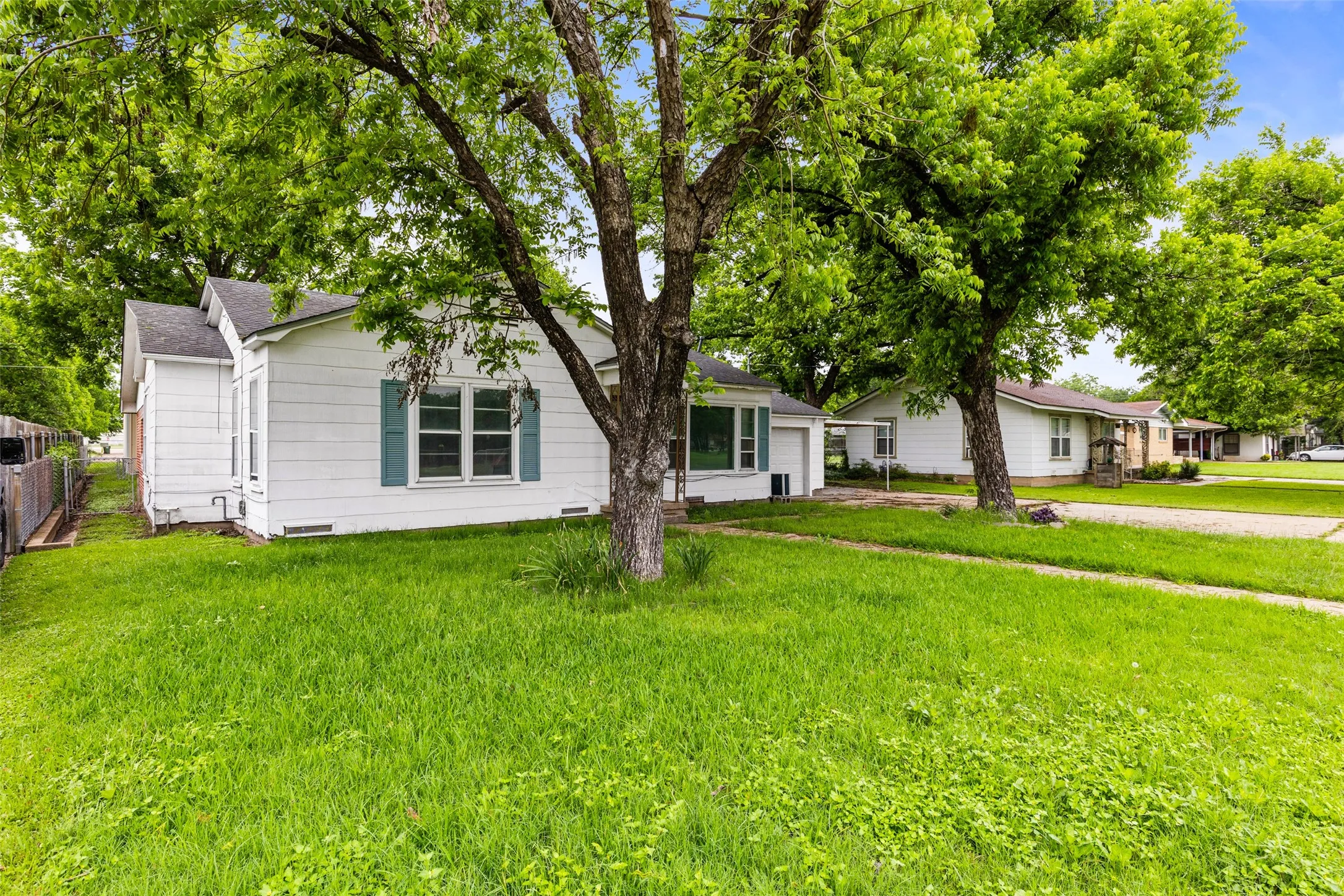 Front exterior with white siding and teal window shutters