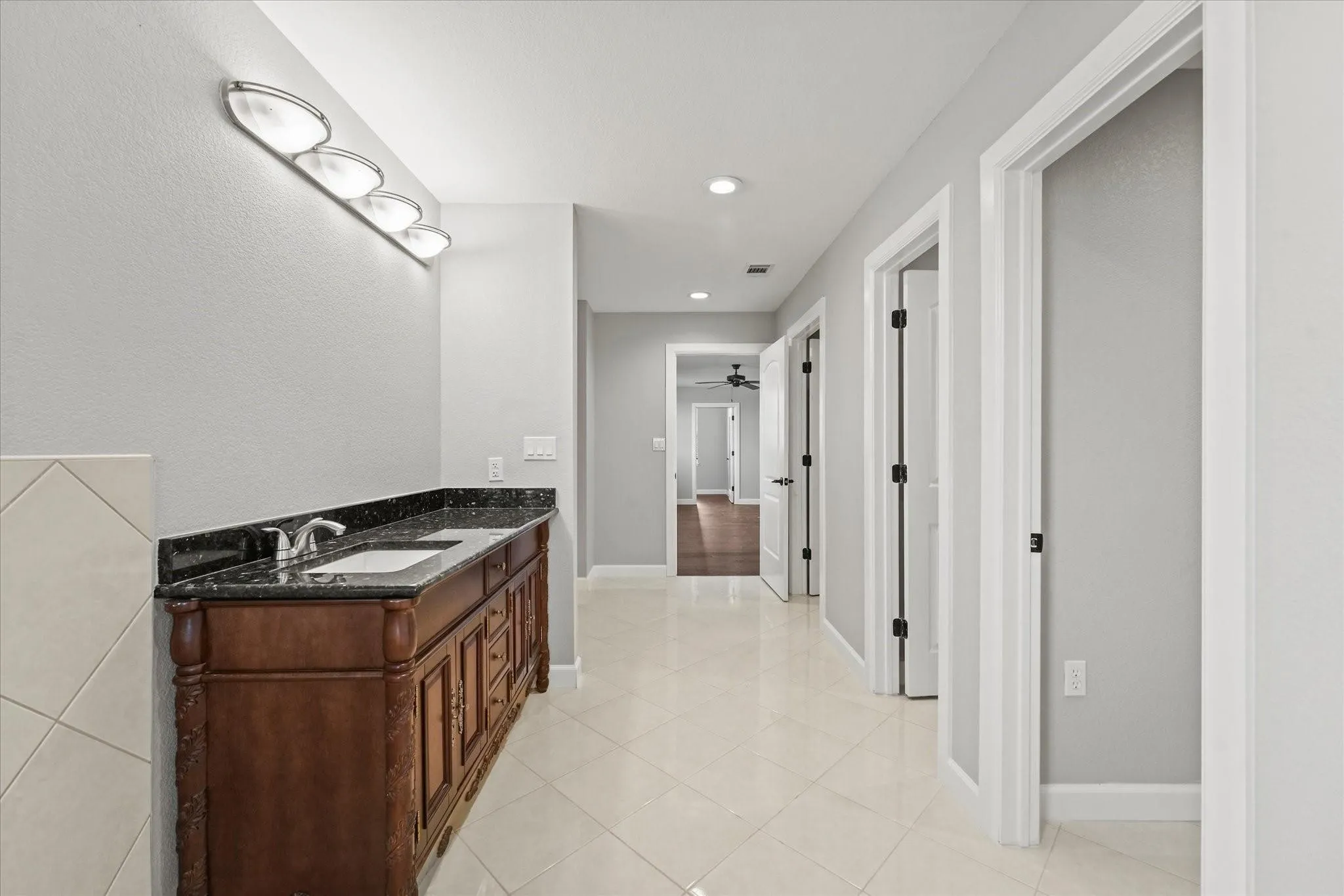 Dual vanity with a dark granite countertop and integrated sinks