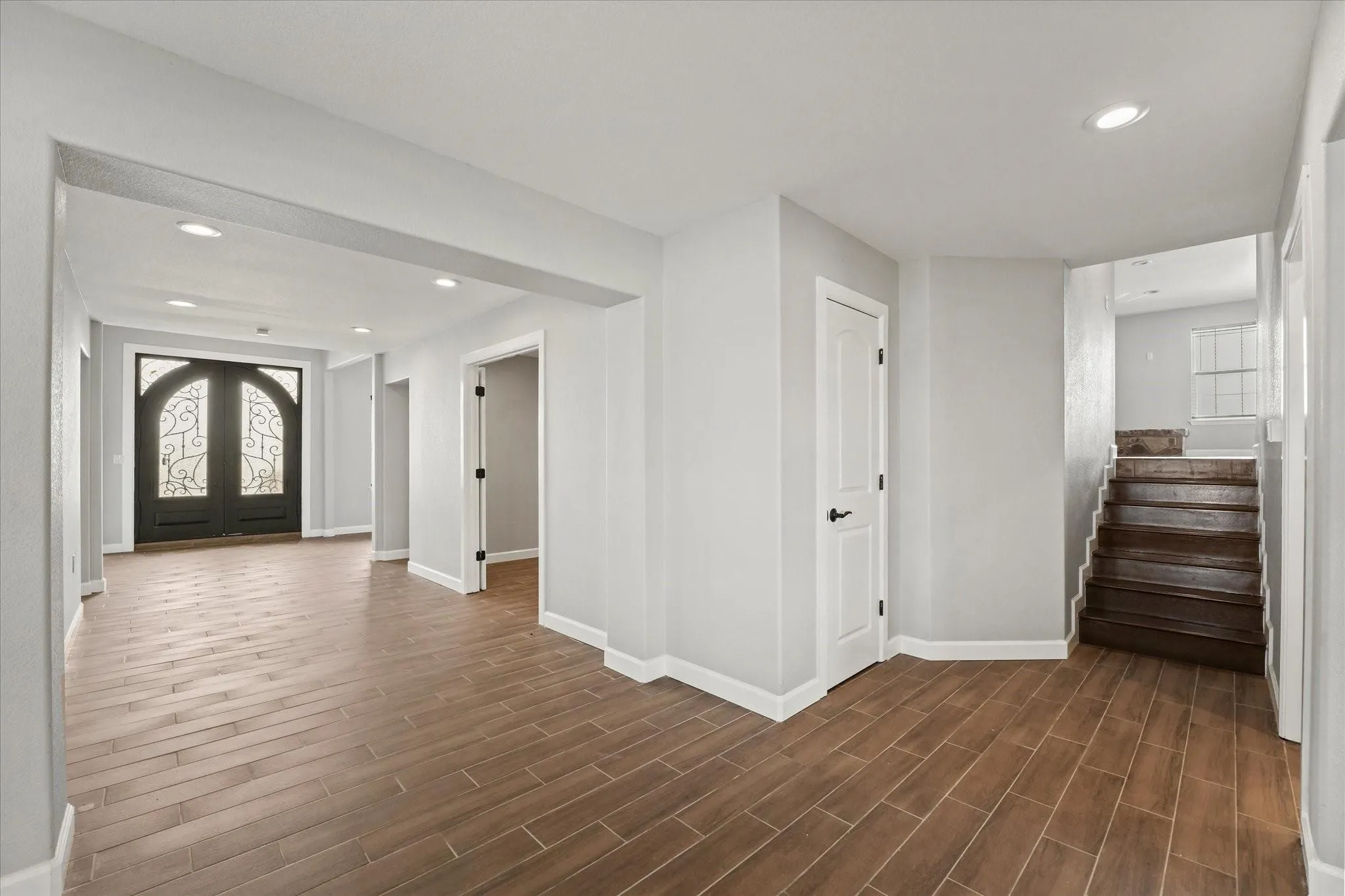 Entryway featuring wood-finish flooring, recessed lighting, and a dark wood double entry door with ornate glass panels